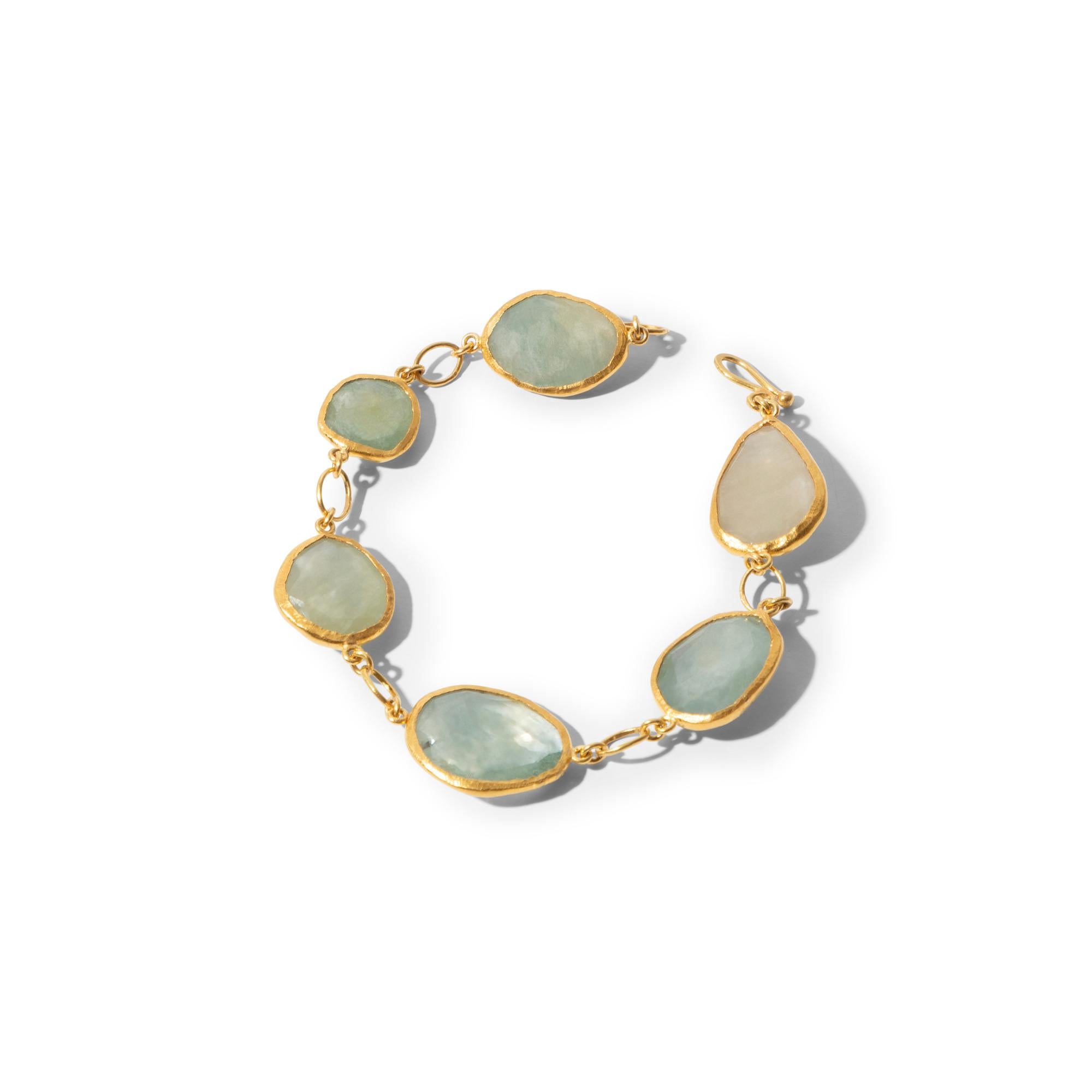 This supremely elegant one-of-a-kind bracelet was completely handcrafted with green random cut sapphires enhanced by a rim of 24k pure gold connected by 22k gold links. It is a timeless piece that will add a touch of bohemian elegance to your