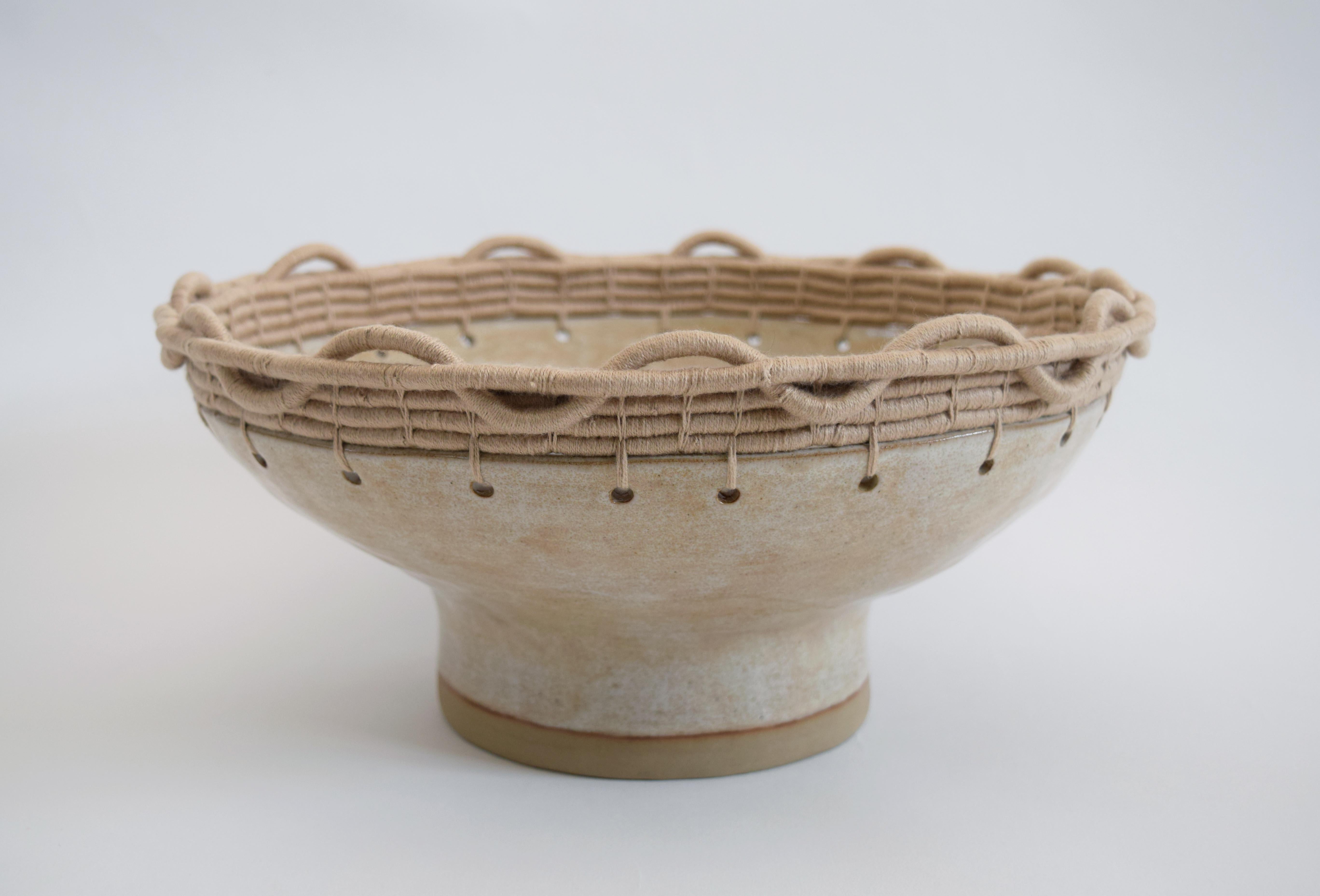 Decorative bowl #792 by Karen Gayle Tinney

Hand formed stoneware bowl with light tan glaze. Woven tan cotton edge detail. For decorative use only.

12.5