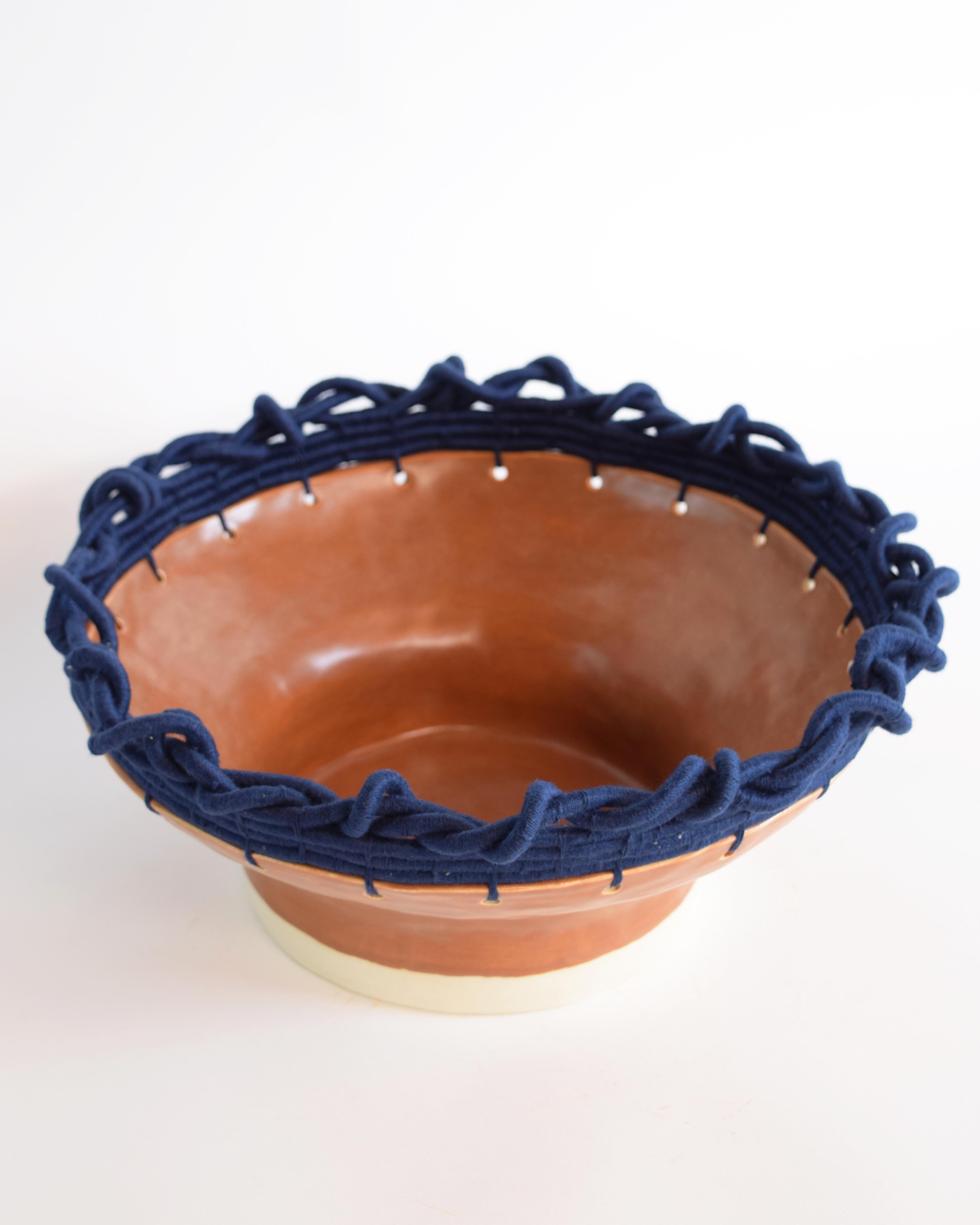 Hand formed stoneware bowl with brown glaze. Woven navy cotton edge detail. For decorative use only.

13