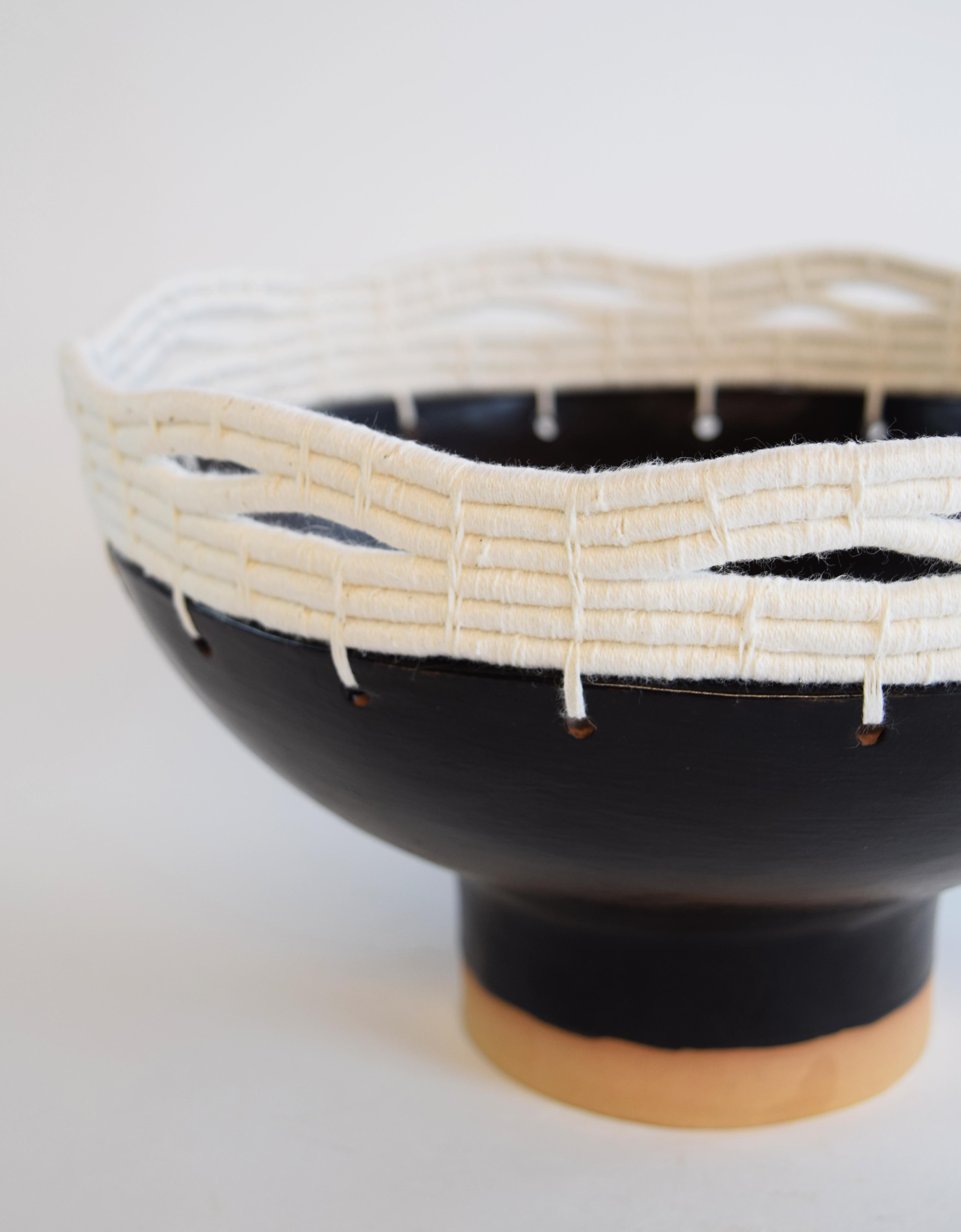 Hand formed stoneware bowl with satin black glaze. Woven white cotton edge detail. For decorative use only.

11