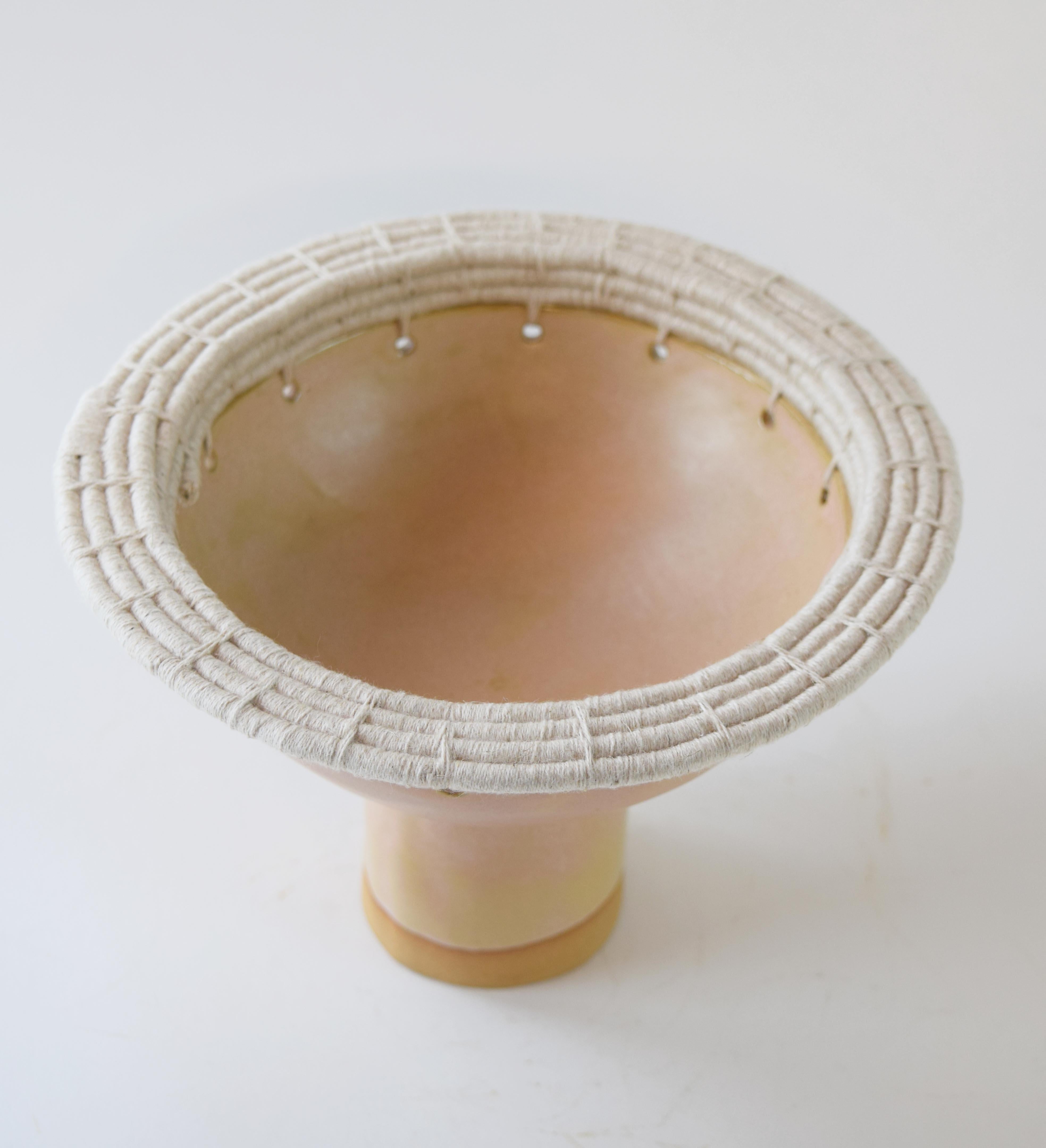 Hand formed stoneware bowl with tan glaze. Woven natural cotton edge detail. For decorative use only.

8.5”W x 6”H

One of a kind collections are released periodically throughout the year. Each piece is meticulously crafted by Karen in her
