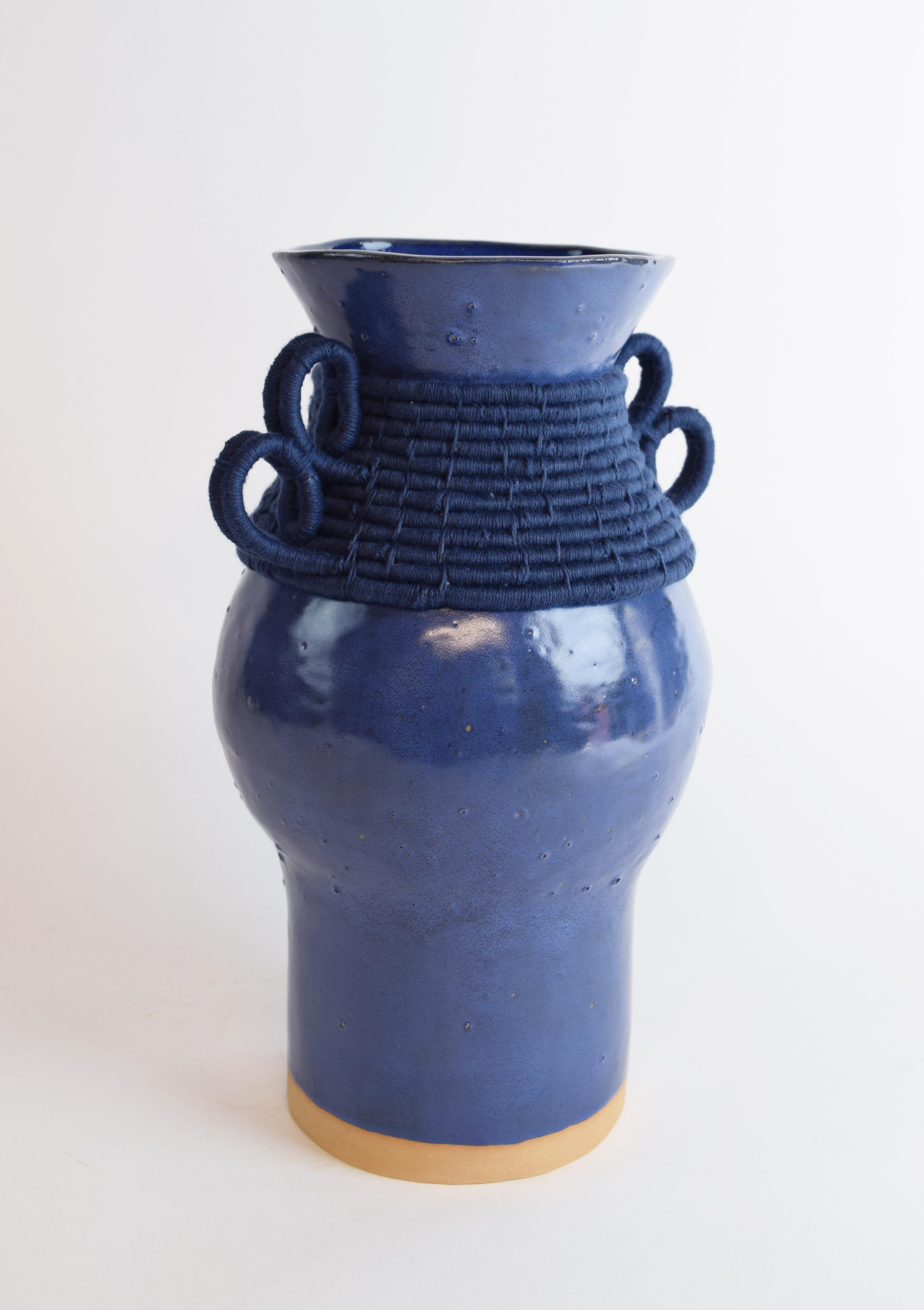 Hand formed stoneware vase with blue glaze. Woven navy cotton detailing around the outside. Vase is water tight.

Measures: 12”H x 8.5”W

One of a kind collections with a limited number of pieces are released periodically throughout the year.