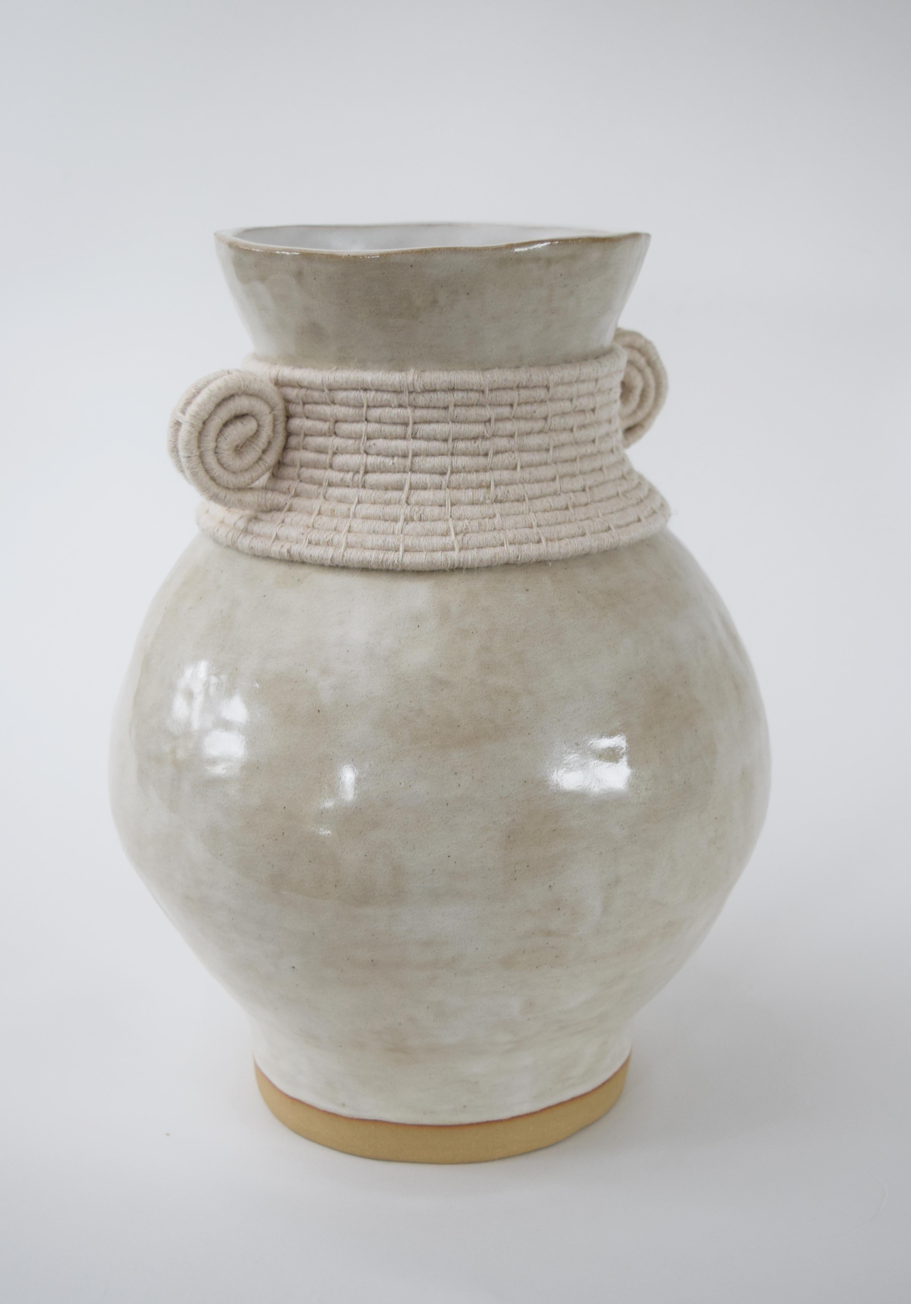Vase #796 by Karen Gayle Tinney

Hand formed stoneware vase with off-white glaze. Woven off-white cotton detailing around the outside. The inside of the vase is glazed, the vase will hold water.

13”H x 9”W

Each piece is meticulously crafted by the