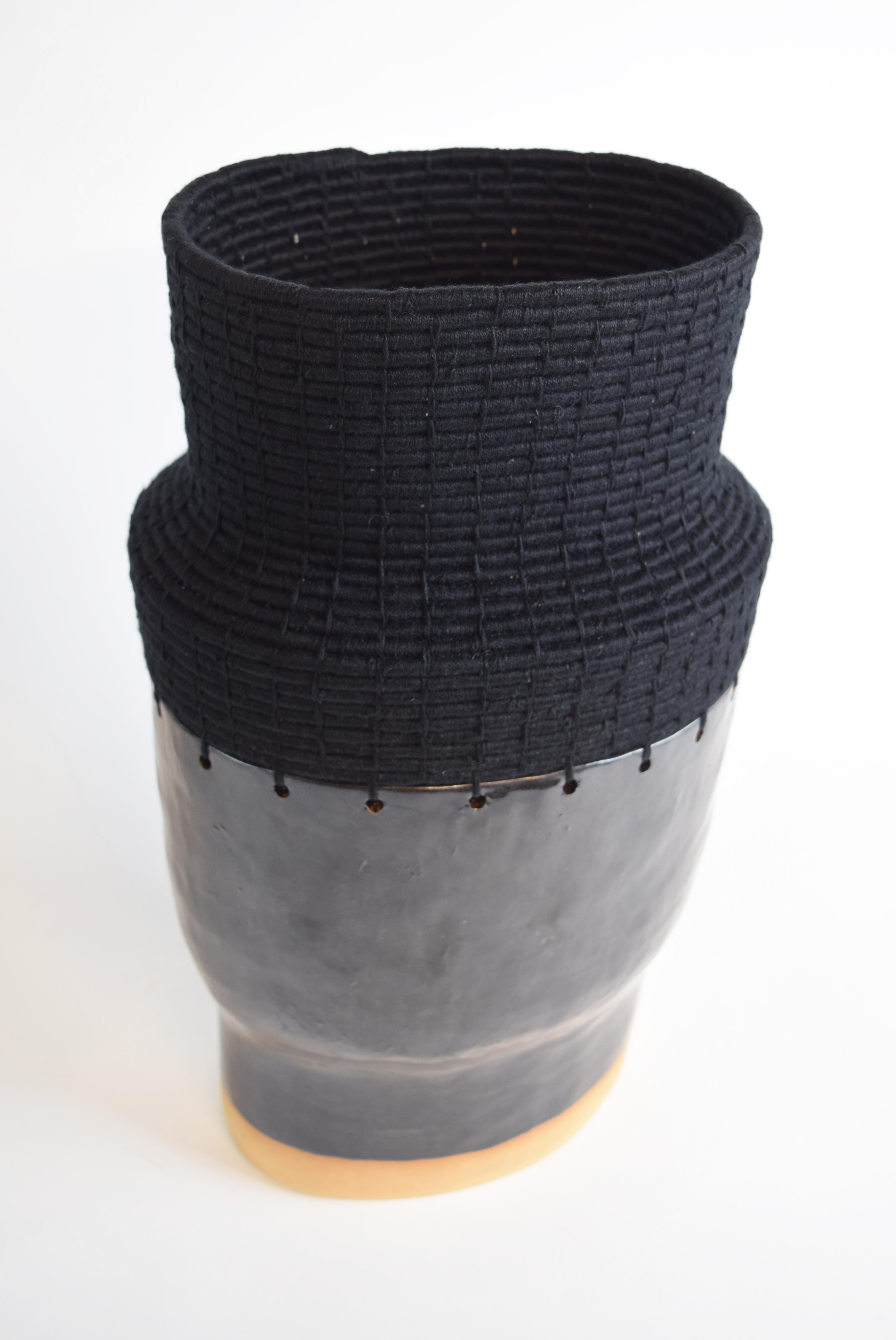 Handgeformter Sockel aus Steingut mit schwarzer Glasur. Der obere Teil ist aus schwarzer Baumwolle gewebt.

16 