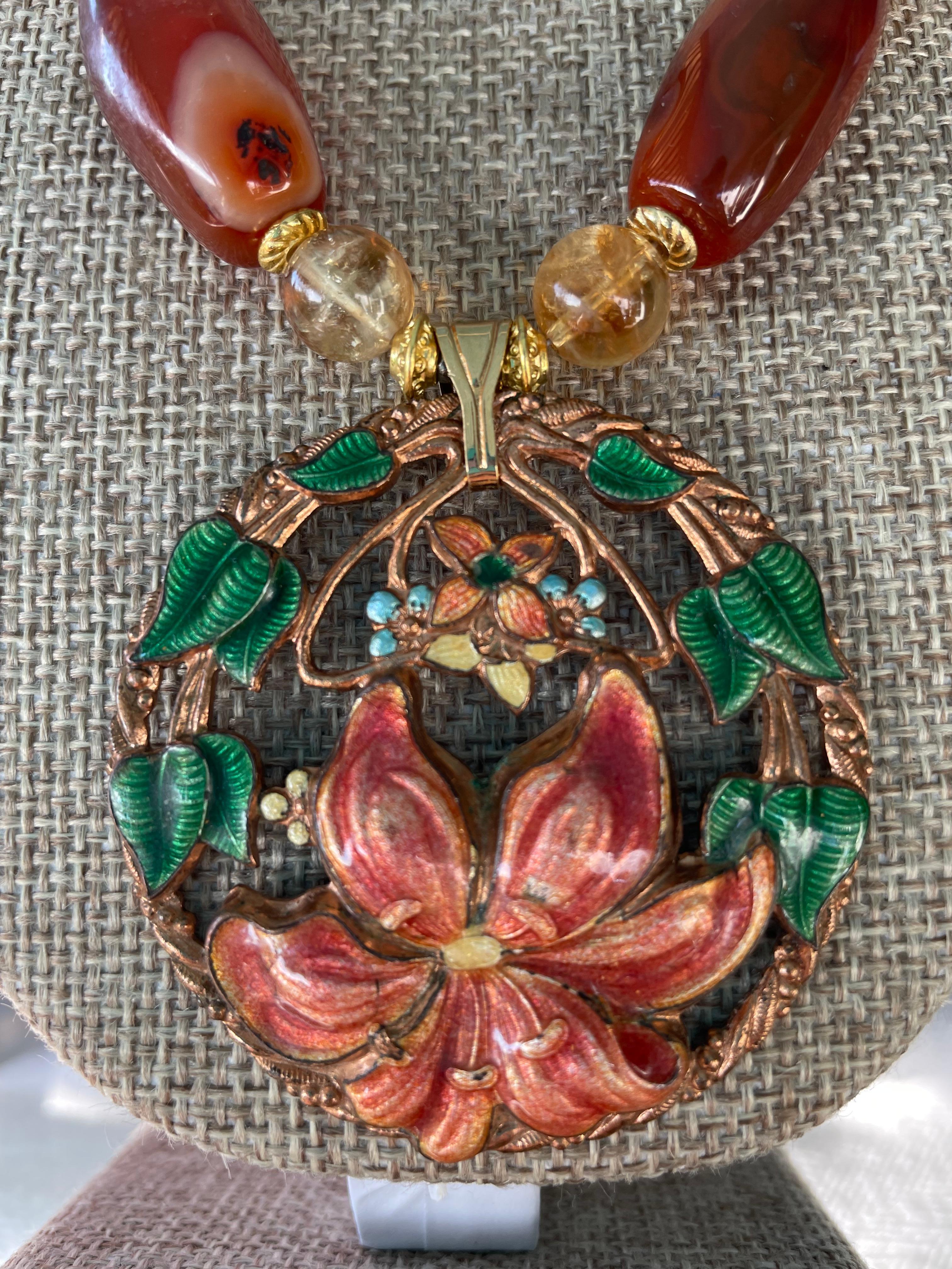 From Lorraine’s Bijoux an original one of a kind,handmade,statement necklace.
A vintage goldtone and enamel brooch is the centerpiece on a string of carnelian,Citrine and Venetian glass beads.This stunning piece would enhance any outfit.A goldtone