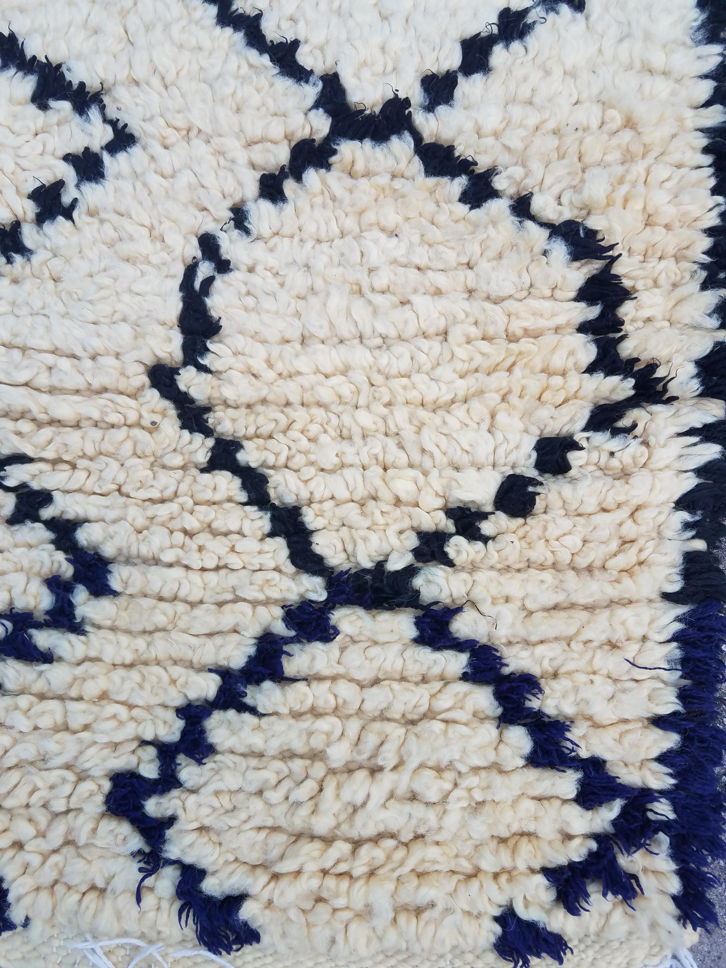 Moroccan black / white (and some blue at one end) Beni Ourain rug. Made of pure wool. Excellent handcraftsmanship. Priced to sell. Measuring approximately 95 cm in length and 32