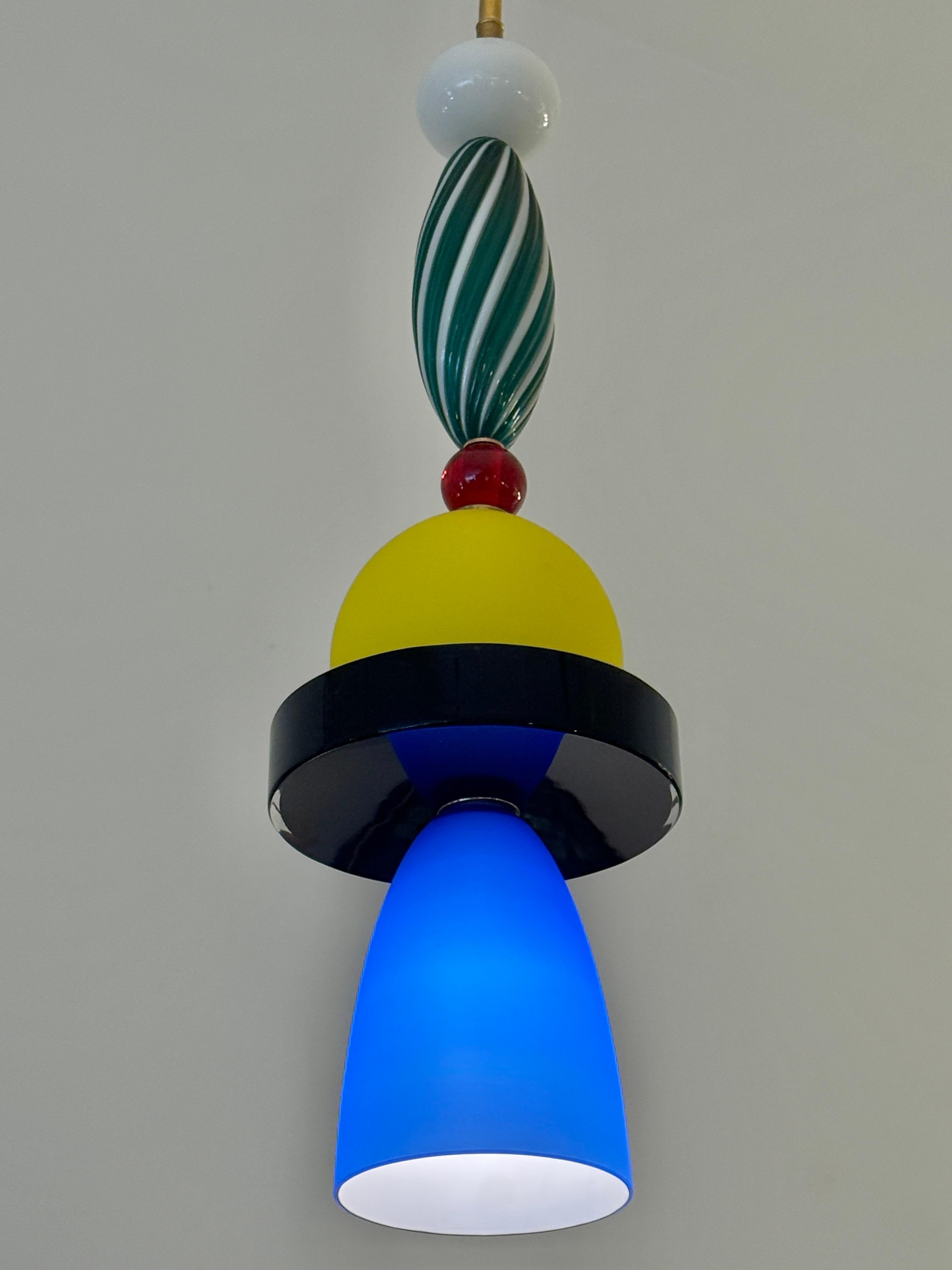 This wonderful 100% unique creation made in Murano, Italy is comprised of vintage Murano glass parts to create this one-of-a-kind pendant light with brass stem and canopy.  Vivid blue, yellow, red and green glass elements.