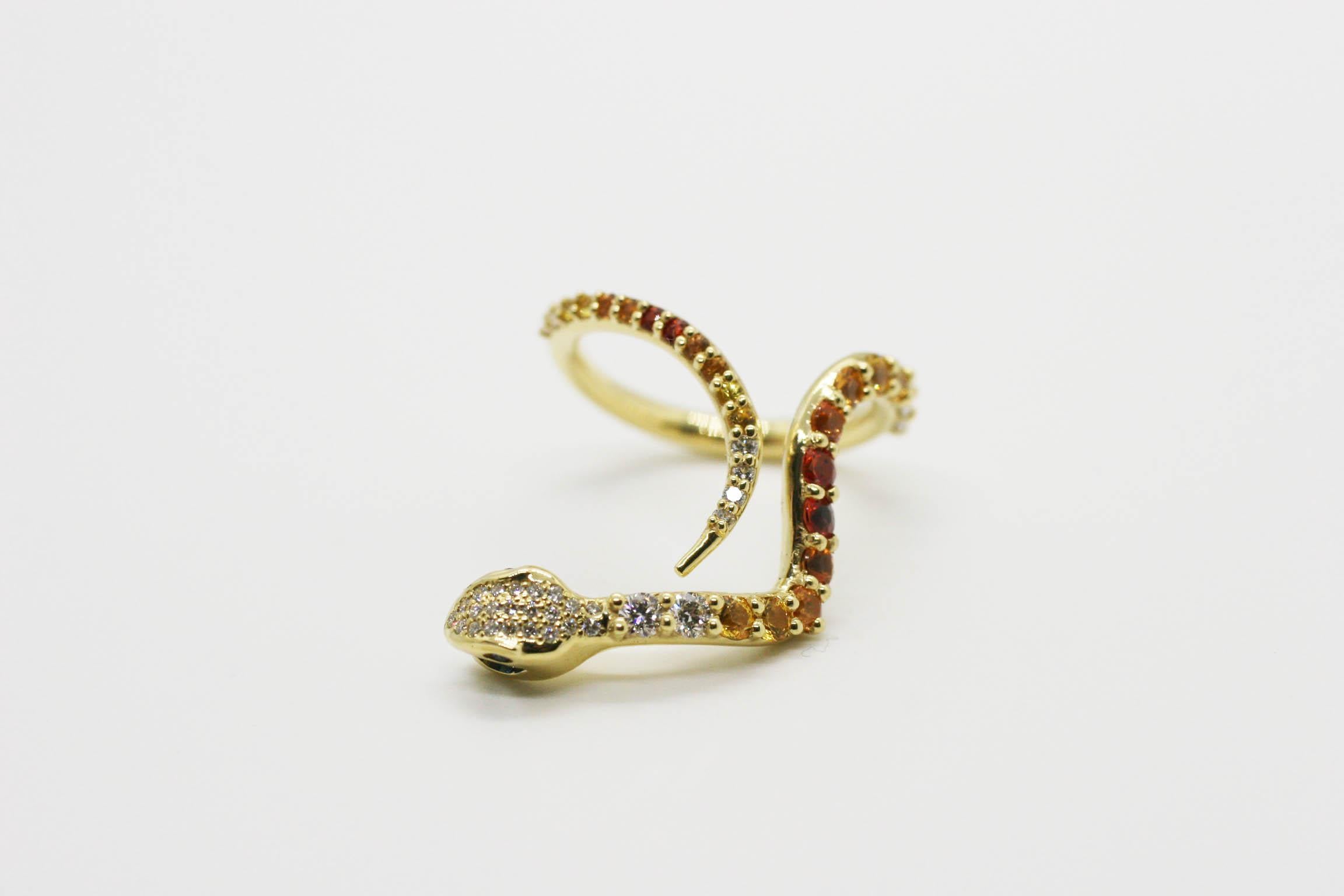 Designer Perez Bitan's signature curved snake ring is designed beautifully to slide over the knuckle and features natural yellow and orange sapphires, white diamonds, blue sapphires in the eyes, and a large blue sapphire in the mouth.  
Set in 18k