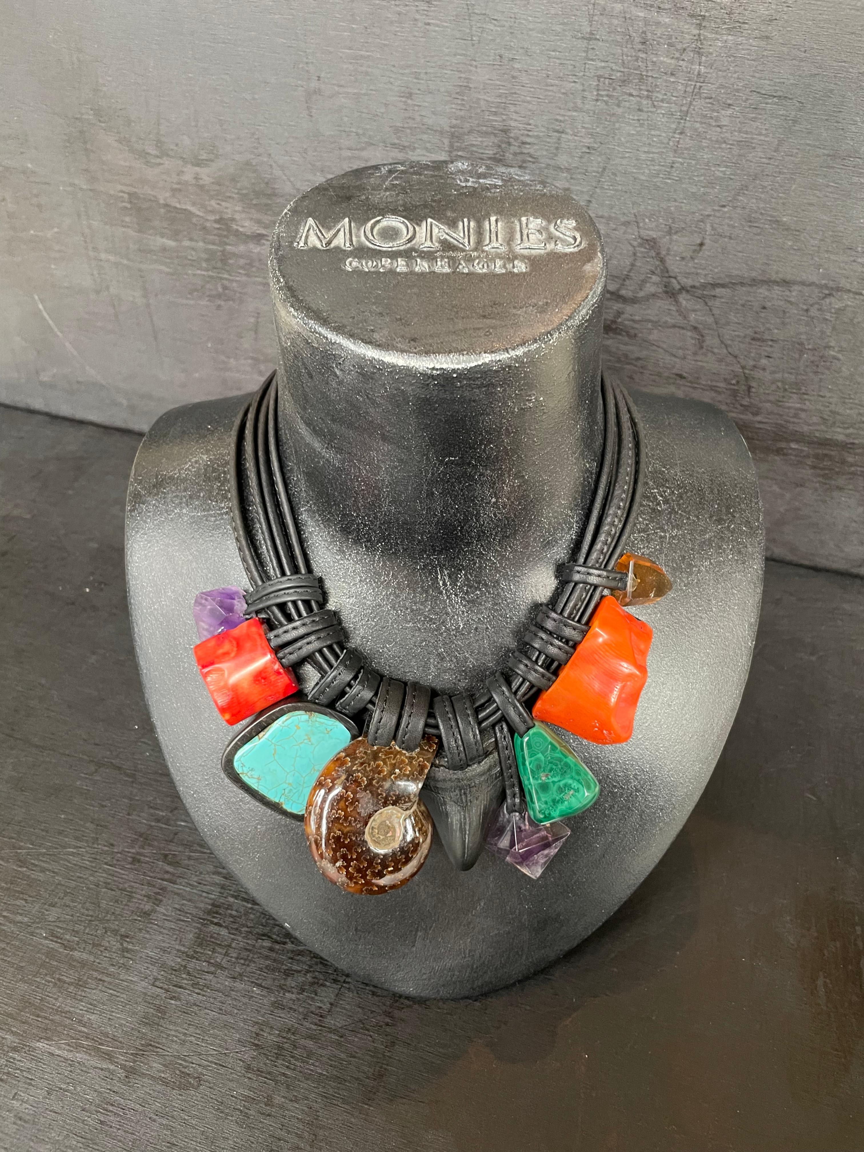 One-of-a-kind statement necklace from the Danish jewellery brand, Monies. 
Made in amethyst, turquoise, coral, ammonite, petrified shark tooth and malachite, with a leather clasp. 

Handcrafted in the Monies Atelier in Copenhagen.