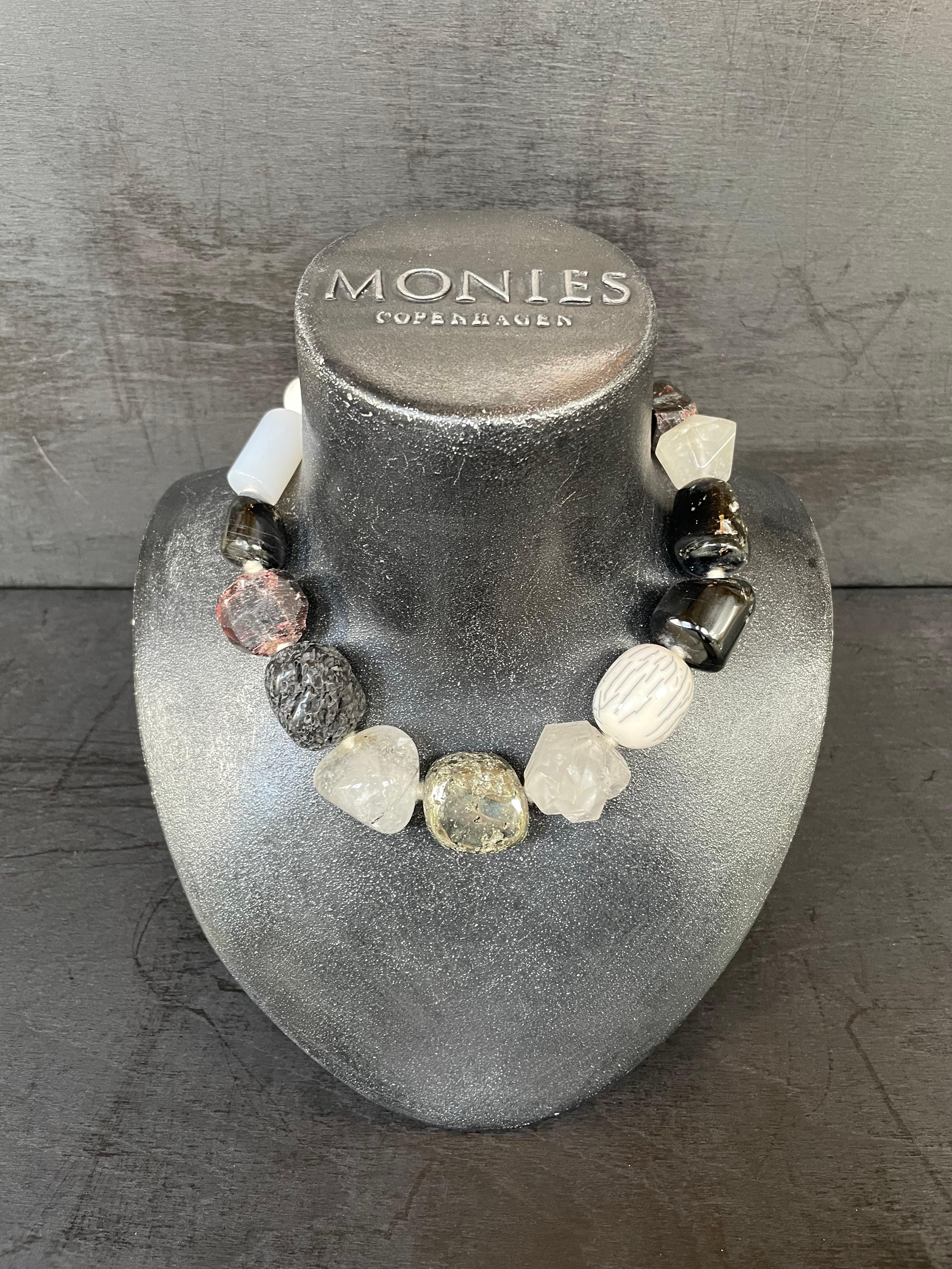 One-of-a-kind statement necklace from the Danish jewellery brand, Monies.
Made in Dolomite, Horn, Tourmaline, Lava Stone and Mountain Crystal with a leather clasp.

Handcrafted in the Monies Atelier in Copenhagen.