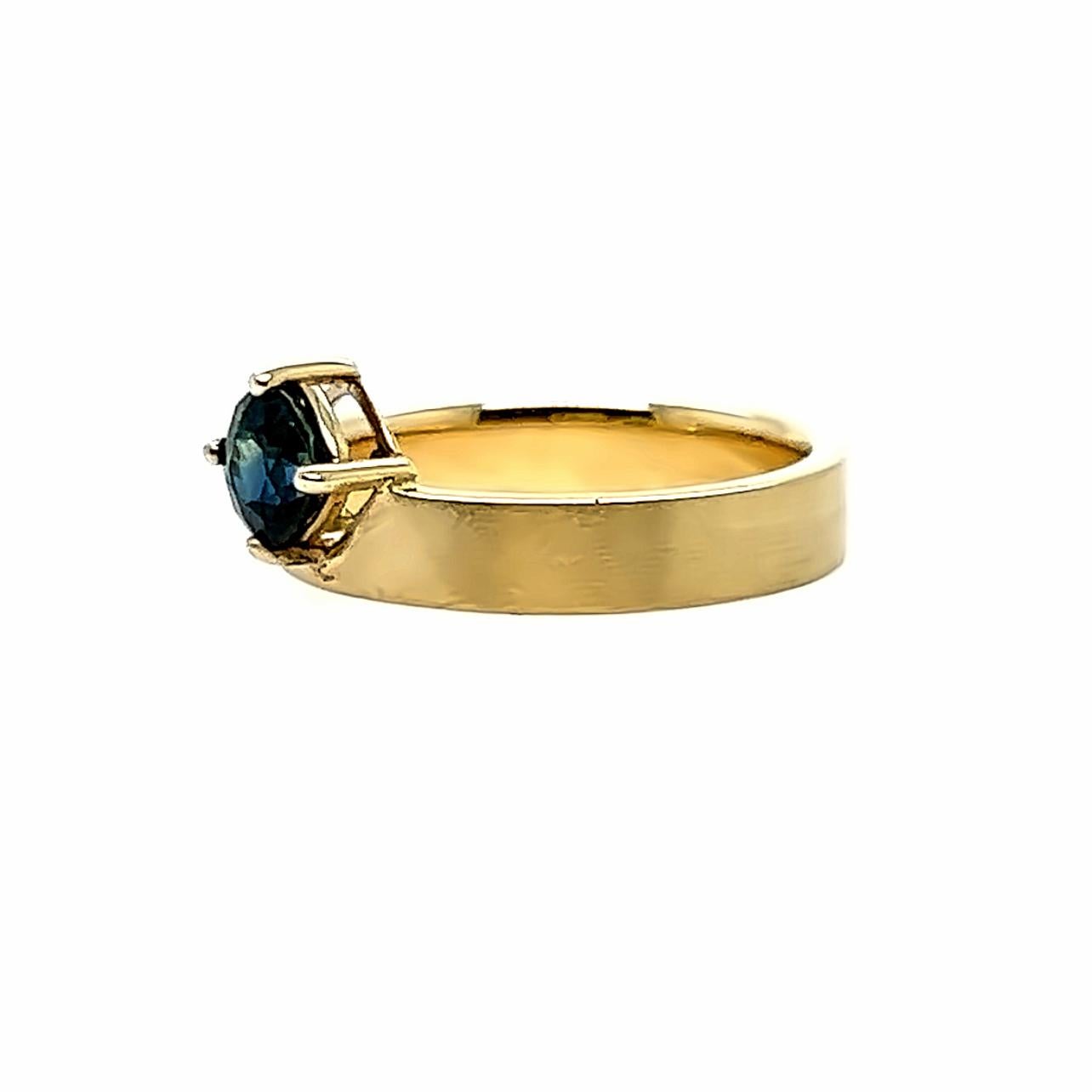 14k solid recycled yellow gold
Blue green natural sapphire, AKA Teal, cushion cut, 5.0-5.0x4.00mm, 0.80ct, Diego Mine, Madagascar. Unheated. 
Flat band, Satin Finish, 4.0mm wide Comfort Fit. 
Size 6.5 and sizable. 

Customization always welcome.