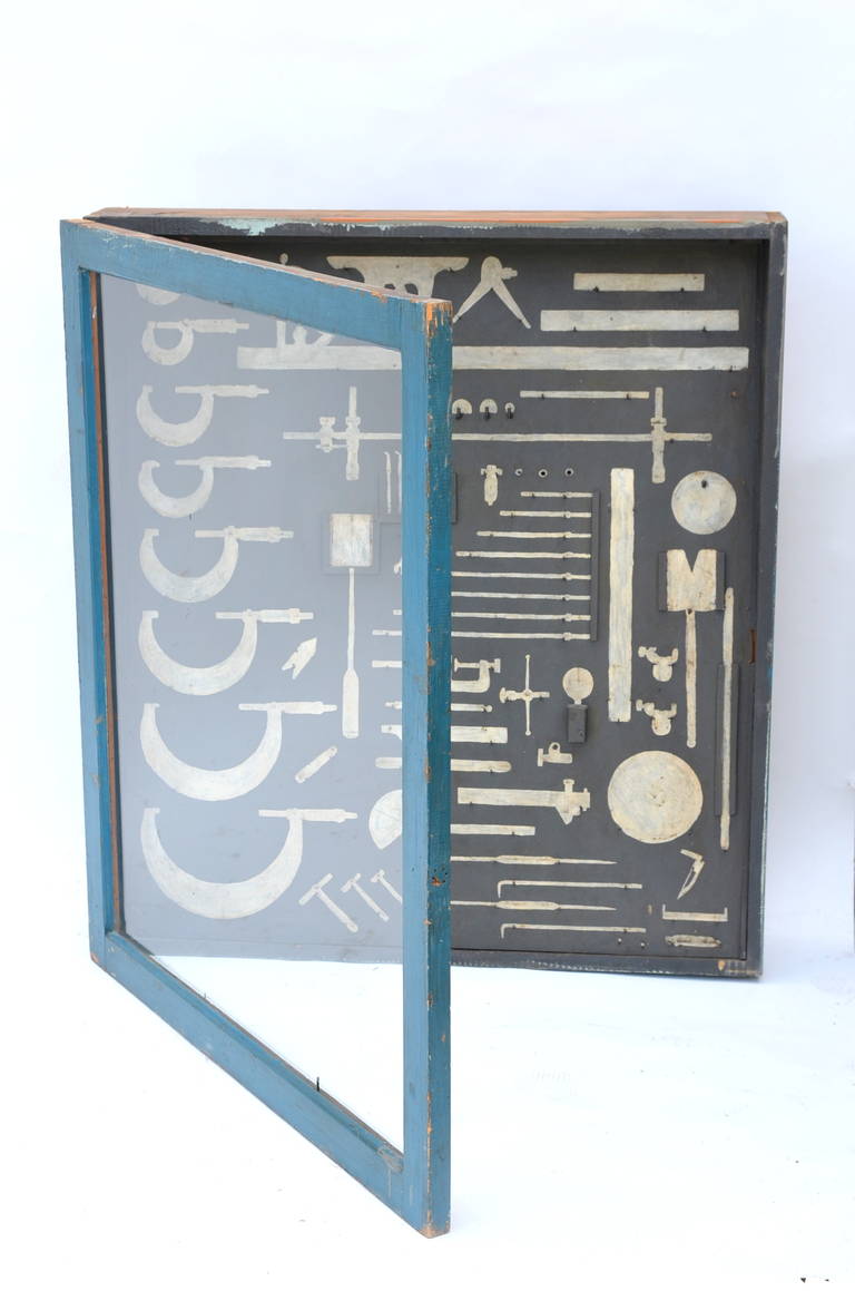 Unique mechanic's tool cabinet, closed with a glass door and hand painted tool shaped with hooks. Can be used as a display case for actual tools or just 