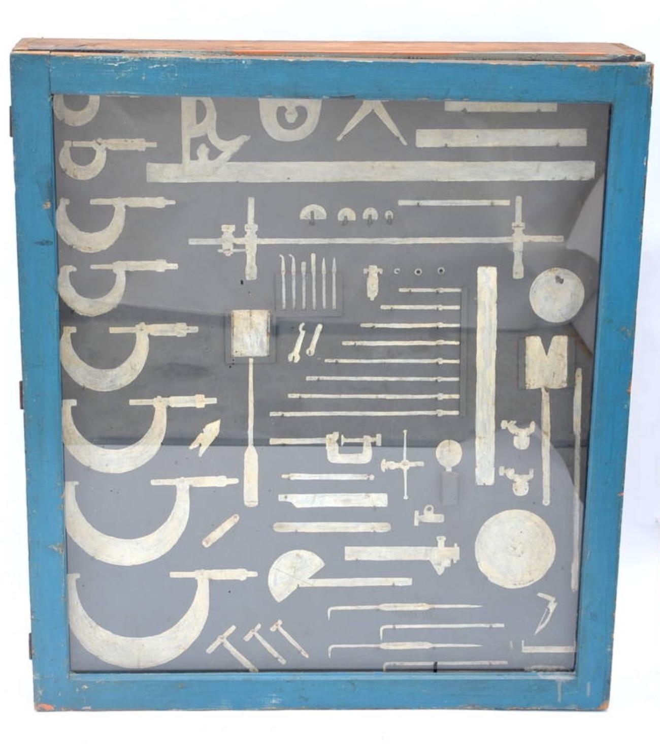 Unique mechanic's tool cabinet, closed with a glass door and hand painted tool shaped with hooks. Can be used as a display case for actual tools or just 