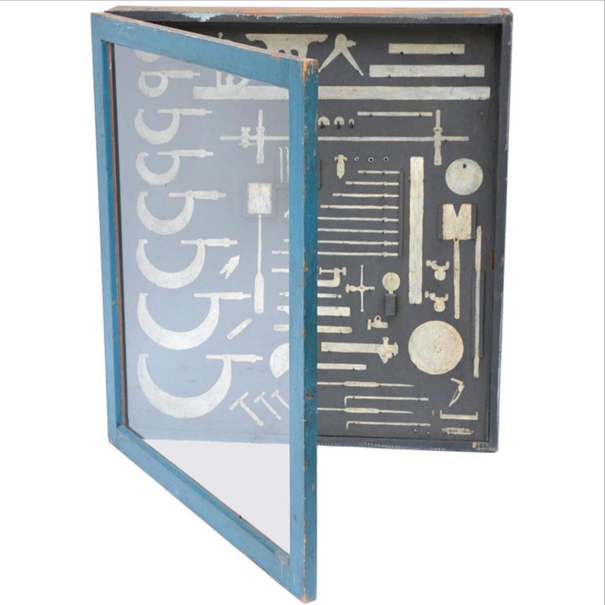 Unique mechanic's tool cabinet, closed with a glass door and hand painted tool shaped with hooks. Can be used as a display case for actual tools or just 