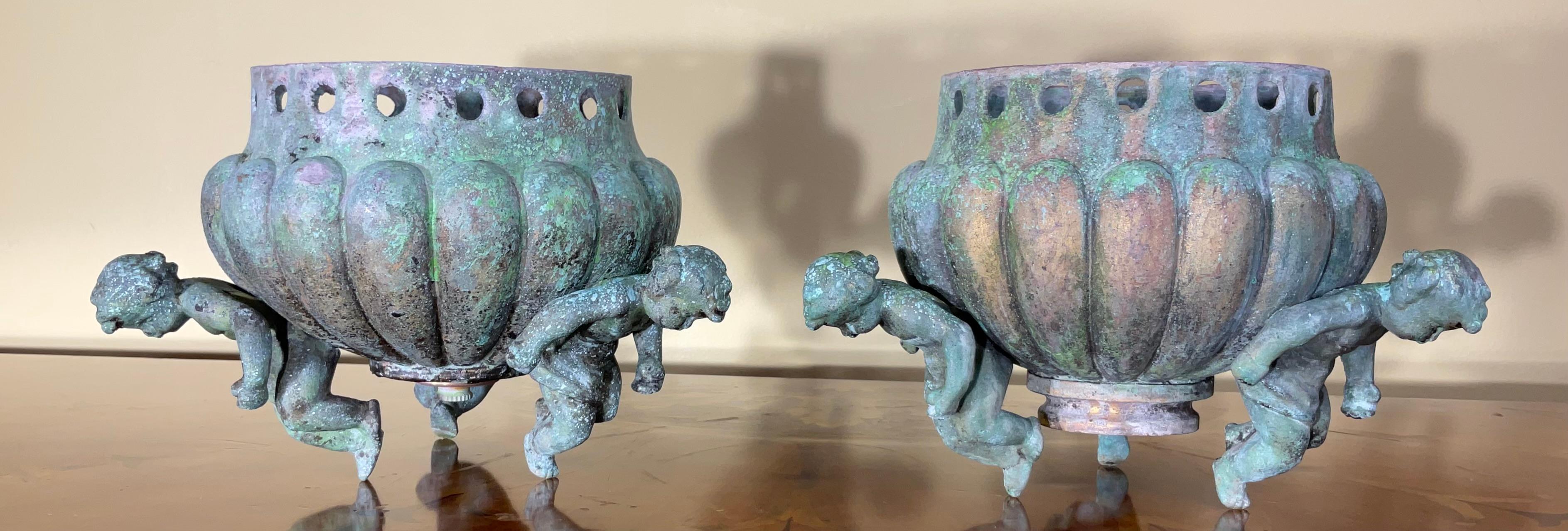 Exceptional antique pair of bronze architectural element salvage ,used as decorative object of art. Beautiful oxidized green-turquoise patina, three bronze cherubs around each of the vessel , one of a kind object of art for display.