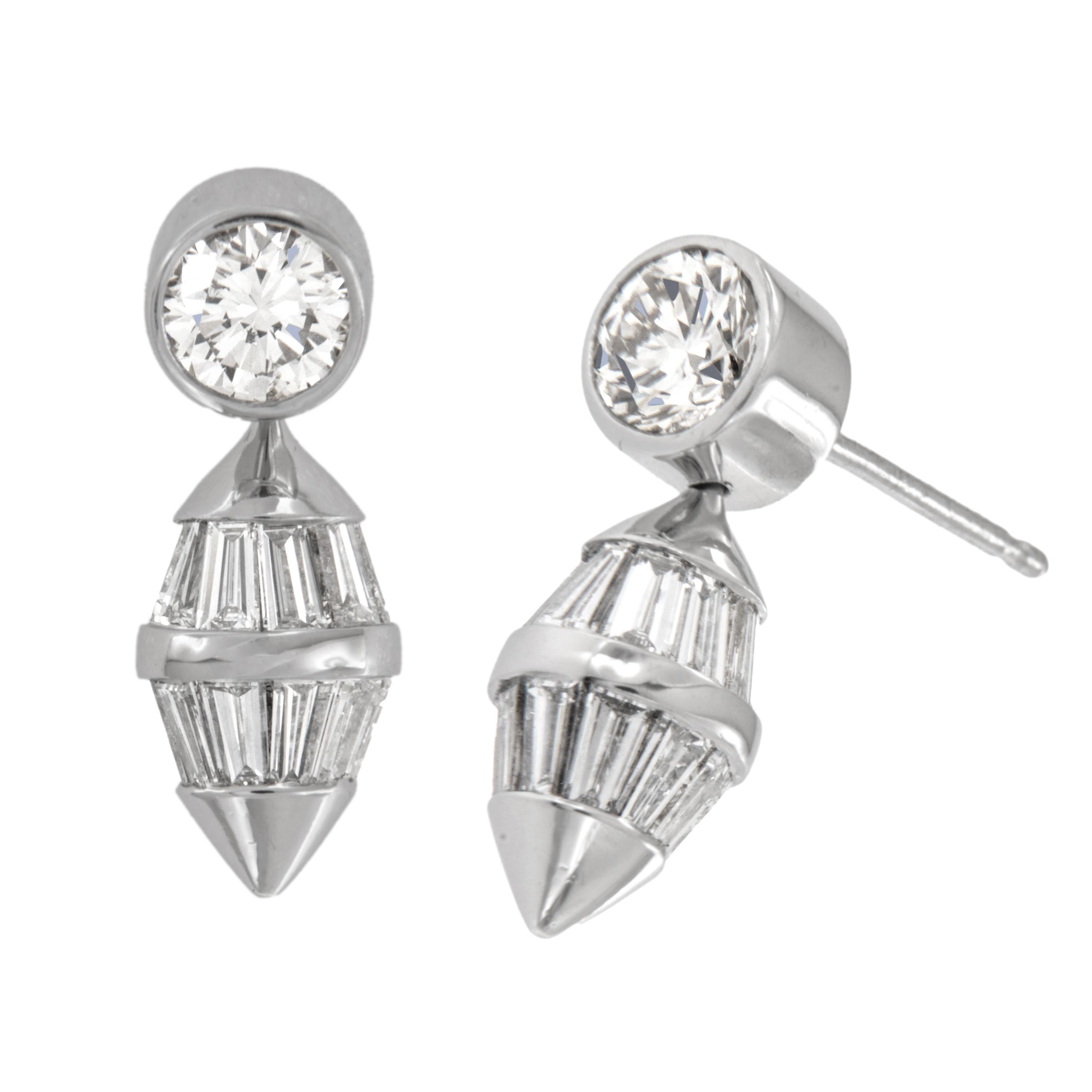 Ces délicieuses boucles d'oreilles sont fabriquées en platine noble, un métal hypogène ! Elles comportent des diamants ronds de 1,00 Cttw à partir desquels des barils de forme effilée sont suspendus de manière rotative - les diamants baguettes de