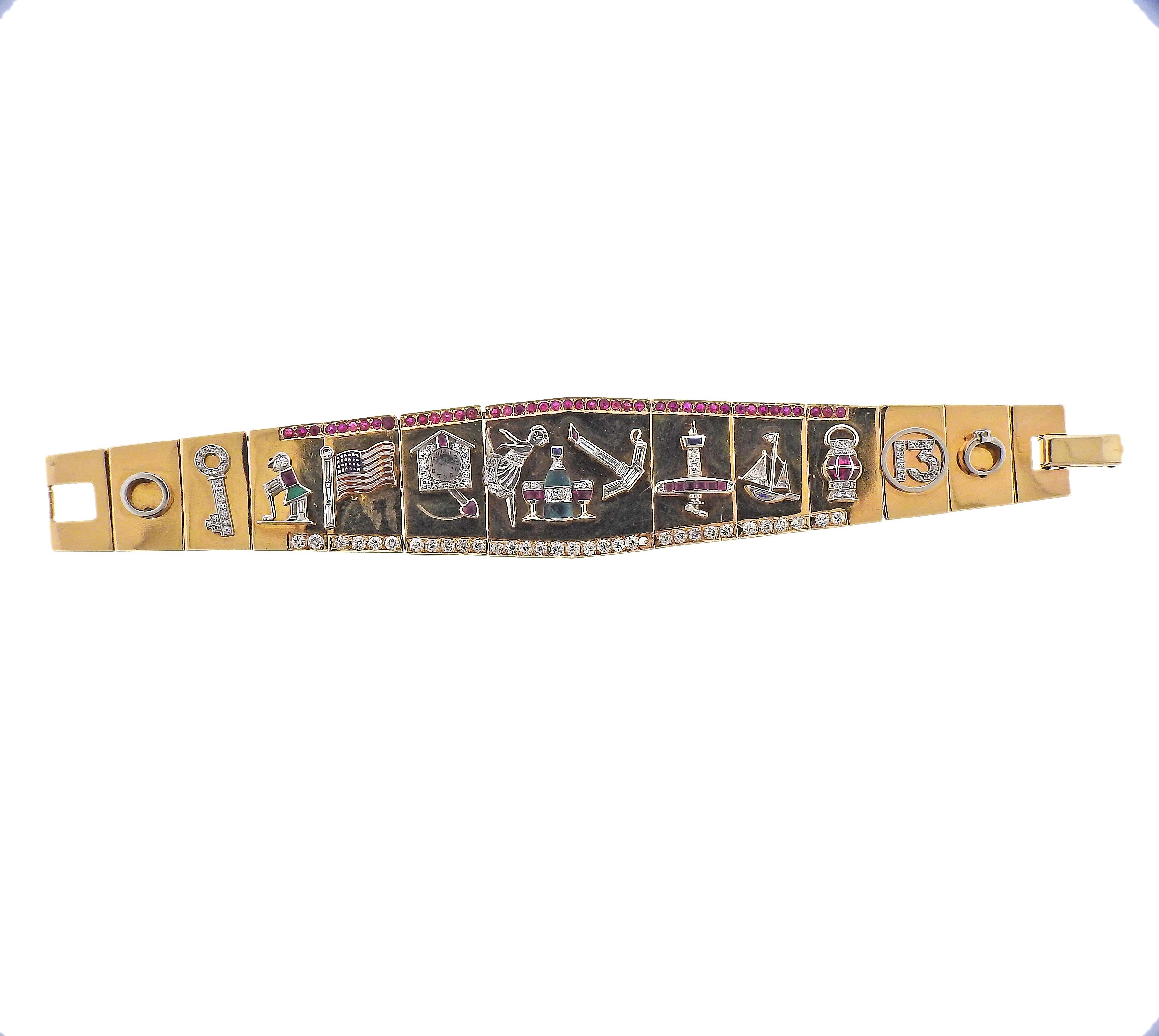 One of a kind 14k gold bracelet with applied charms, set in gold and platinum, adorned with rubies, sapphire and green gems (multiple stones are abraded and have chips) surrounded with approx. 2.00-2.20ctw in diamonds (one is missing). Bracelet is
