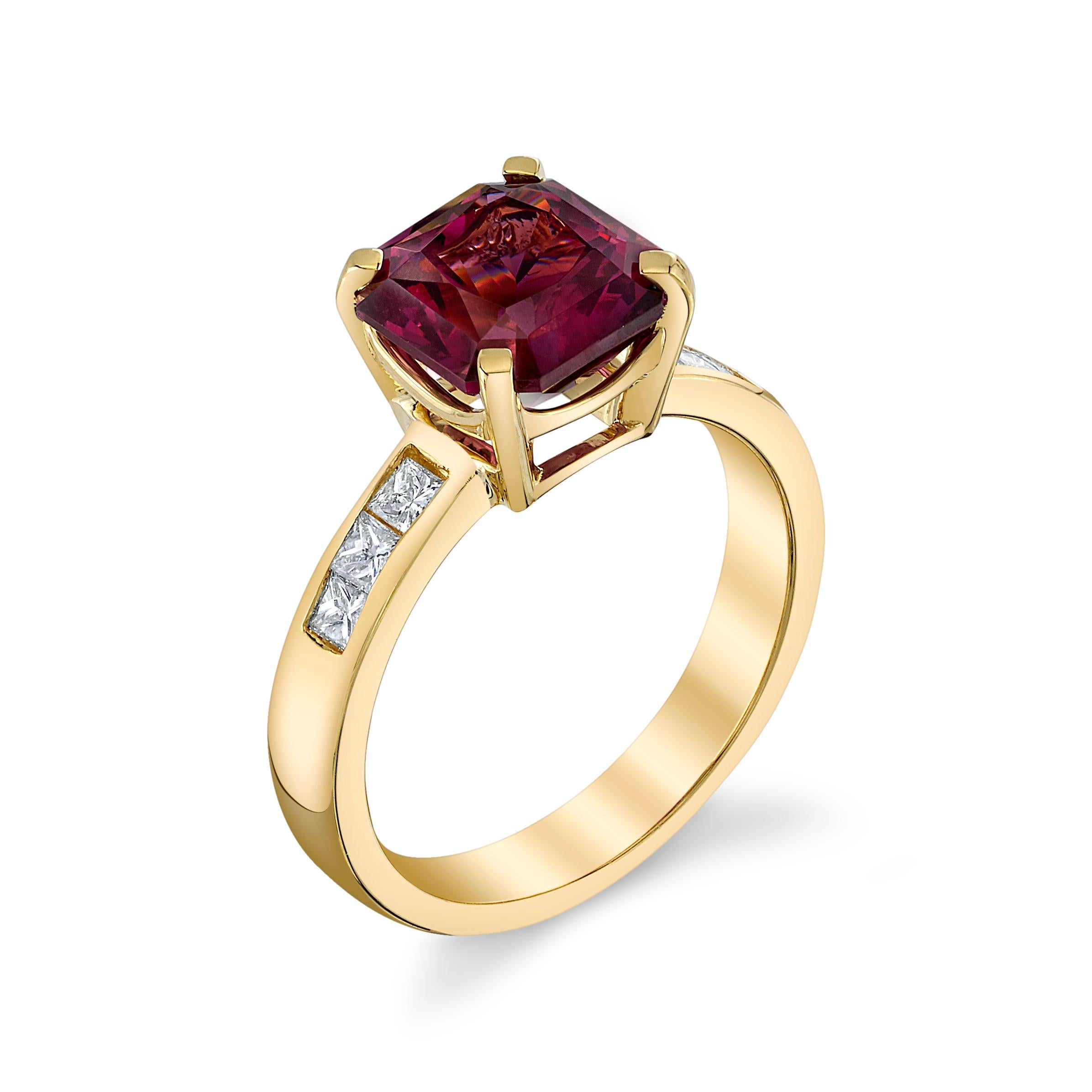 Questo anello senza tempo presenta un granato rodolite da 3,12 carati abbinato a sei diamanti taglio princess incastonati a canale per un totale di 0,42 carati sul gambo. 

La designer ha acquistato questo splendido granato rodolite a un'asta e non