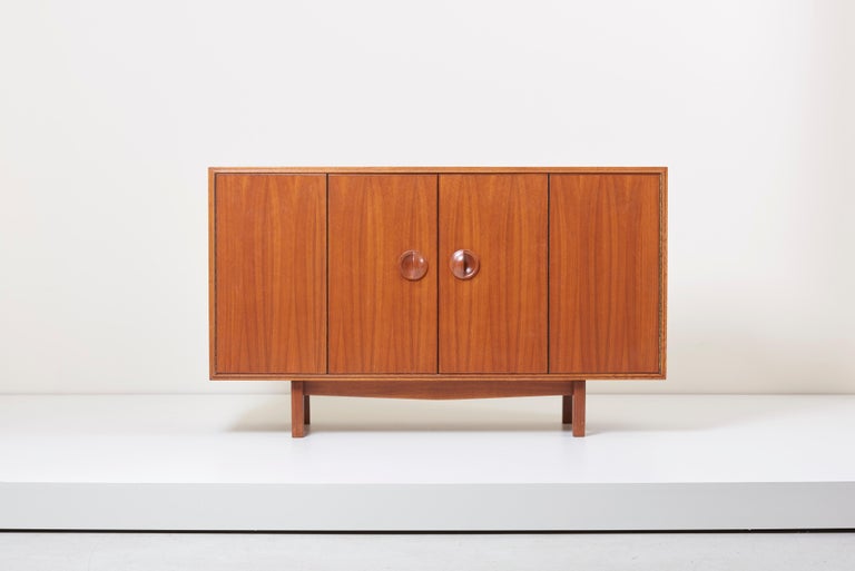 1960s sideboard or cabinet designed by John Kapel. Made from beautifully selected walnut and oak. This cabinet has sculpted walnut handles and the interior is fitted with adjustable shelves and two drawers so as woodworking handcrafted details. A