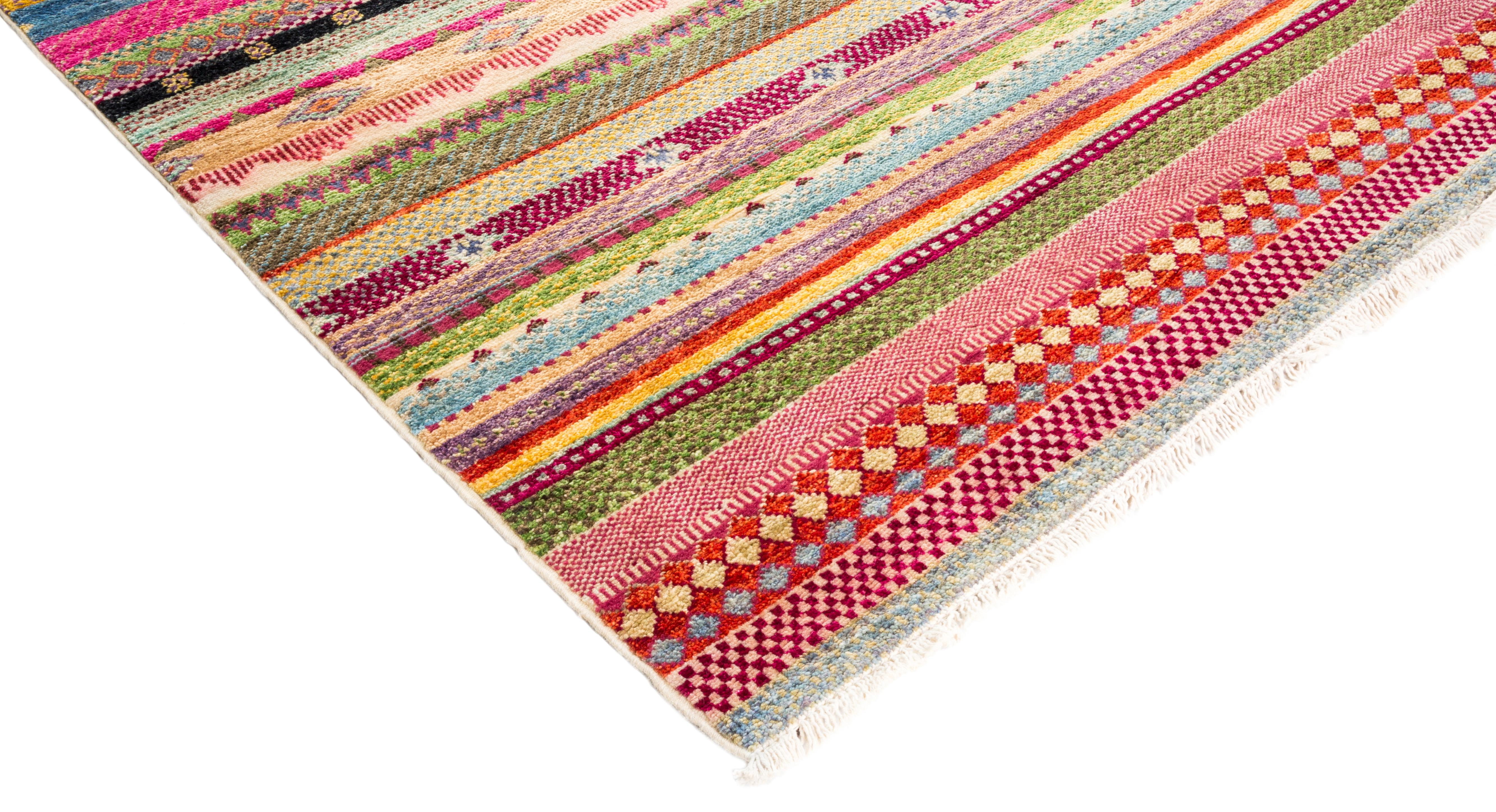 Color: Pink - Made in: Pakistan. 100% wool. The rich textile tradition of western Africa inspired the Tribal collection of hand knotted rugs. Incorporating a medley of geometric motifs, in palettes ranging from earthy to vivacious, these rugs bring