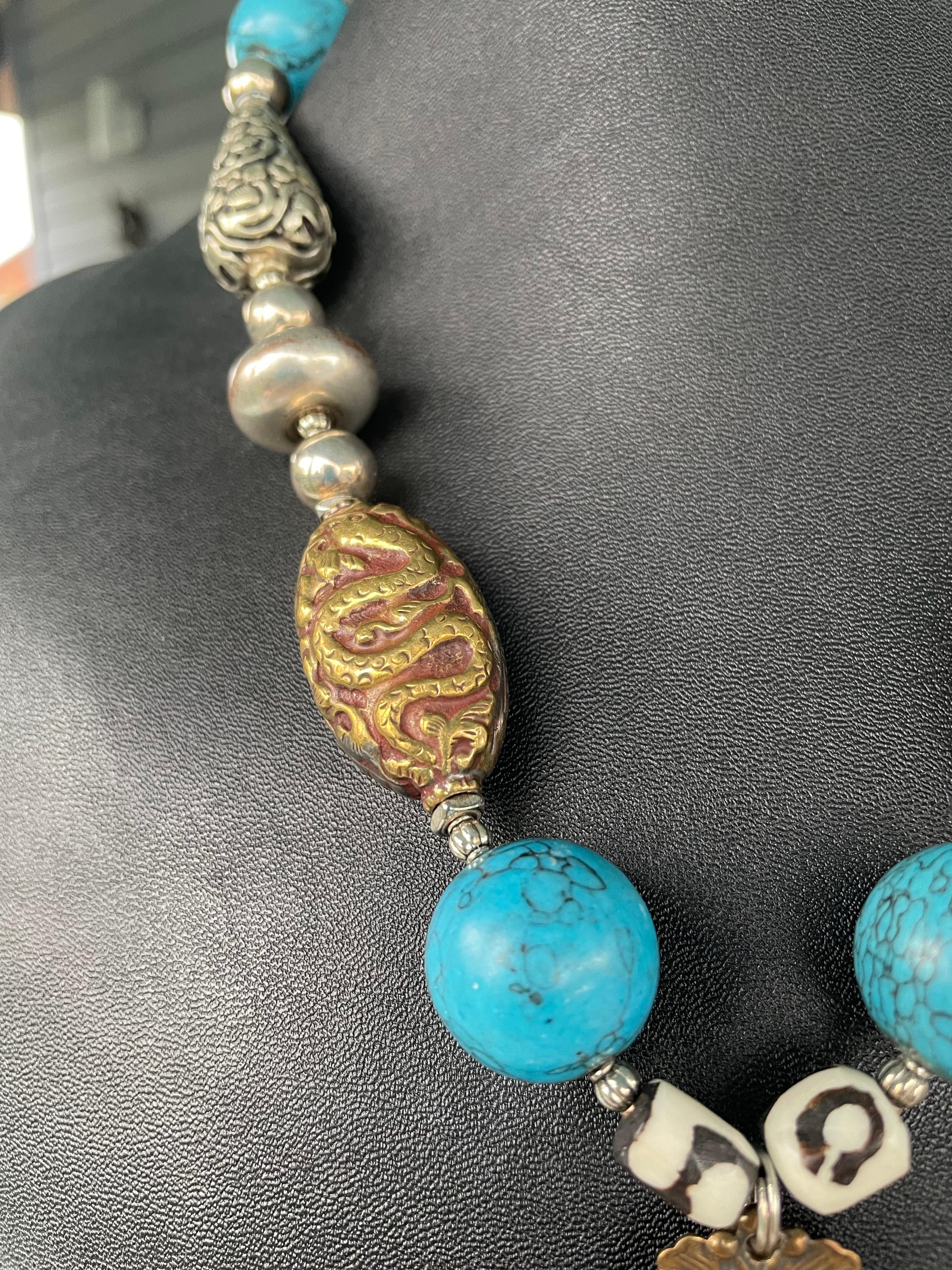 One of a kind ,handmade,statement necklace with sterling,vintage elephant brooch pendant on a string of turquoise,Tibetan brass and silver repousse beads. Sterling silver Mexican rondelles and African mud beads are included.
