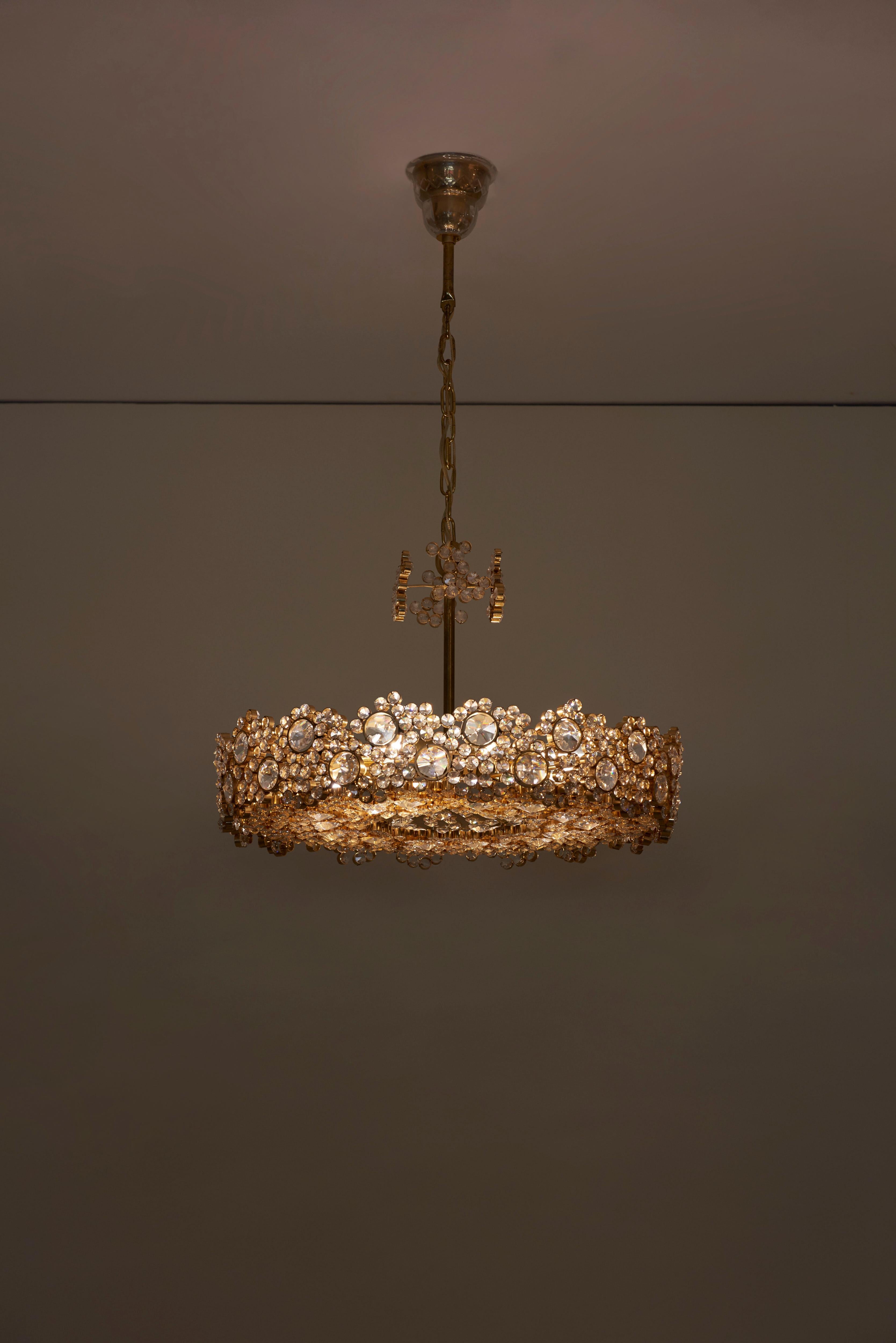 One of seven outstanding Palwa chandeliers from the 1960s, model S101. The 24-carat gold-plated brass frames are encrusted with hundreds of high quality diamond like crystals. The chandeliers are handmade and in excellent condition and float every