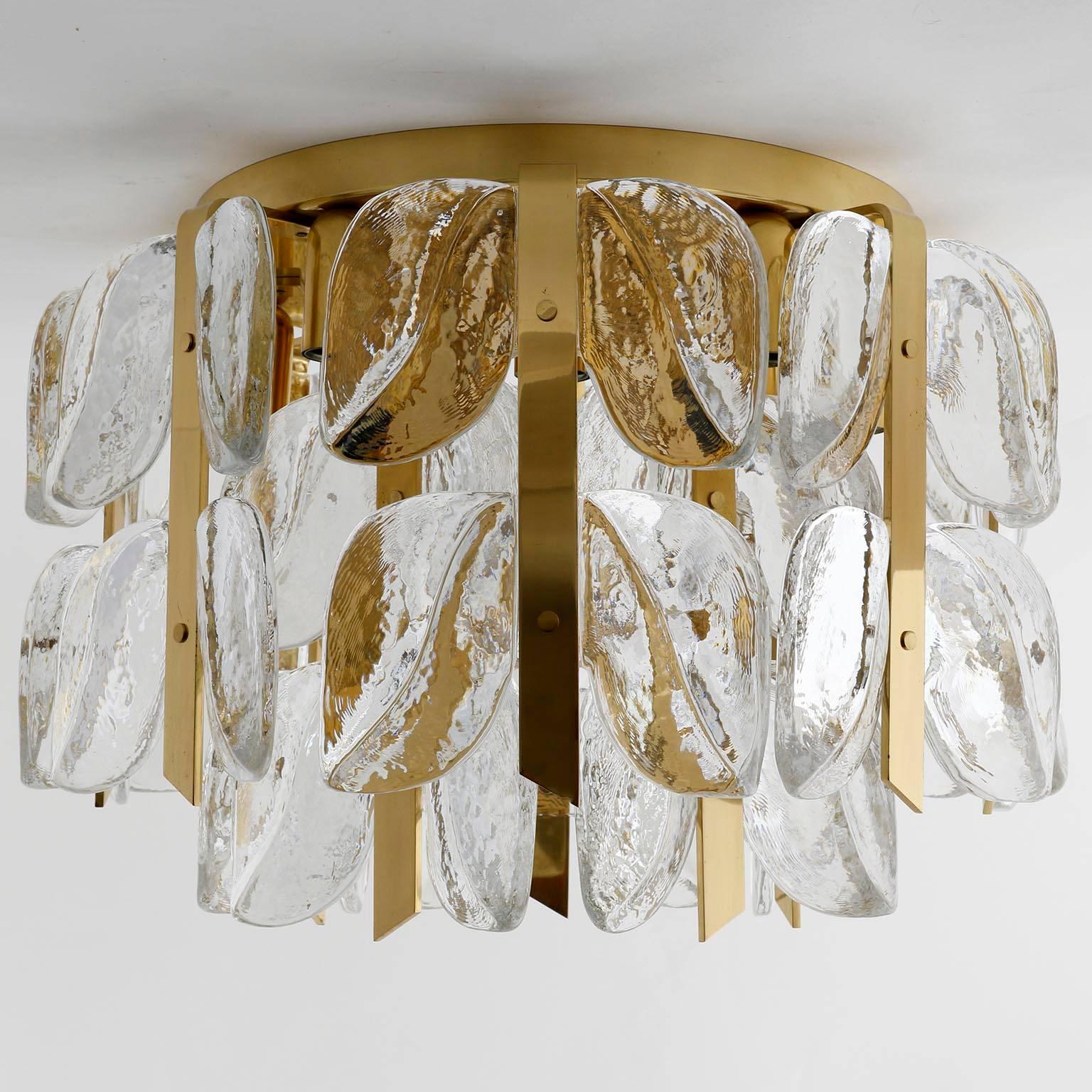 One of two high quality flushmount light fixtures model 'Florida' by J.T. Kalmar, Austria, manufactured in midcentury, circa 1970 (late 1960s or early 1970s).
These Hollywood Regency lights are made of polished brass and large fire-polished
