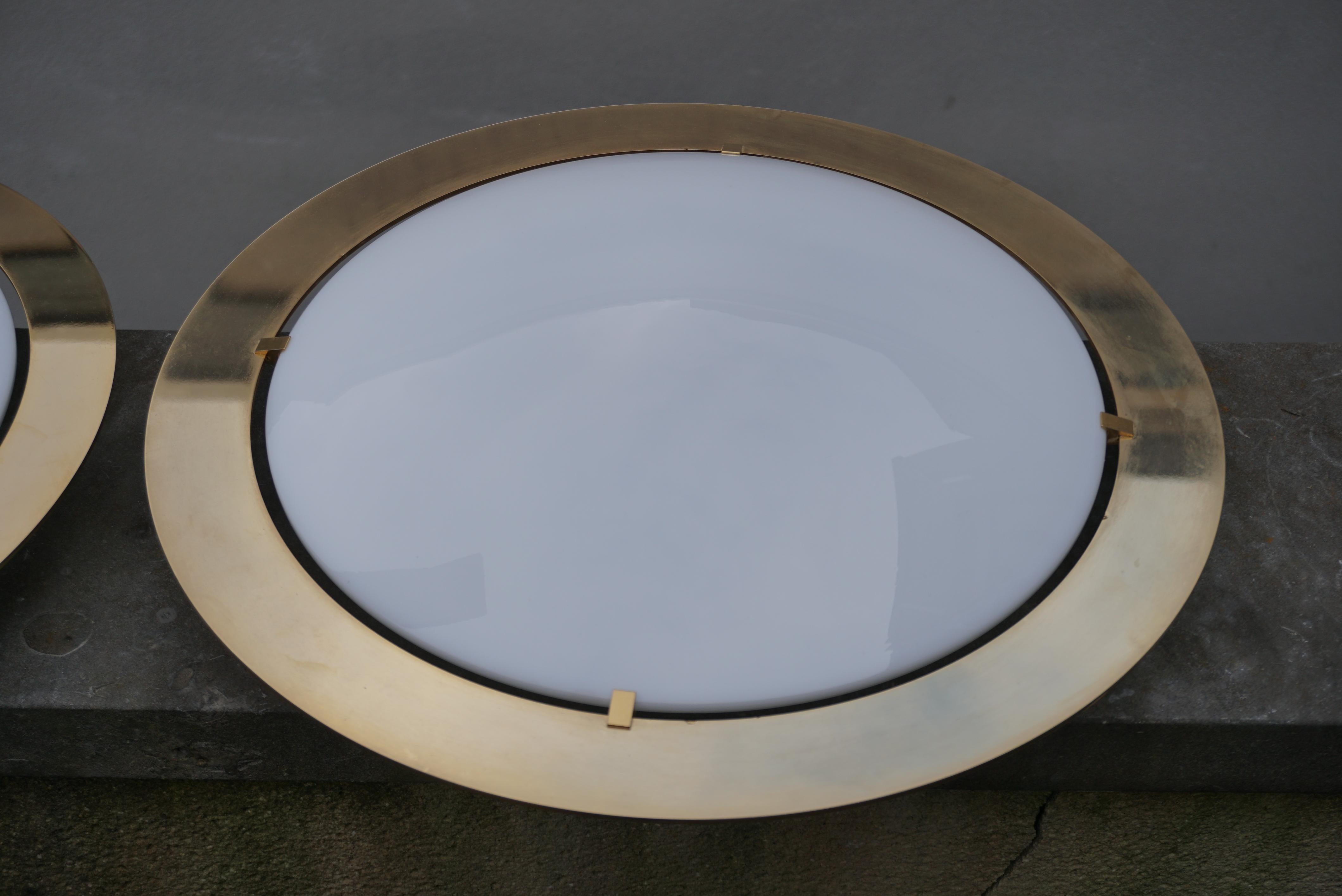 One of four flush mount lights or sconces by Glashütte Limburg, manufactured in midcentury, circa 1970. They are made of a polished brass armature with a dome shaped opal glass lampshade. Labelled with Glashütte Limburg. 
The price is per light.
