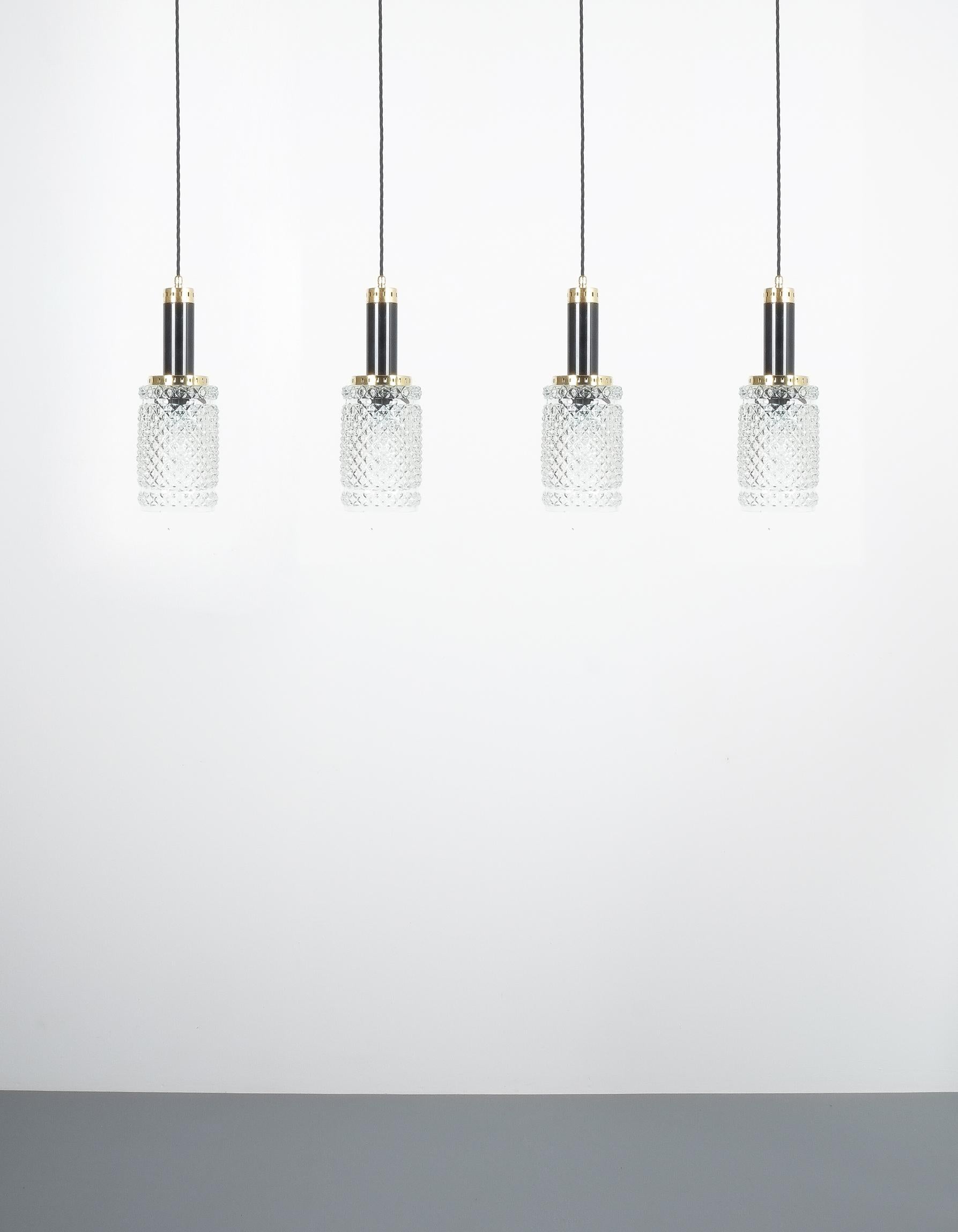 Una delle quattro lampade a sospensione in vetro cristallo attribuite a Stilnovo, circa 1962

Set di quattro luci a sospensione in vetro testurizzato - Prezzo per articolo. Bellissime lampade a sospensione italiane con dettagli in metallo nero e