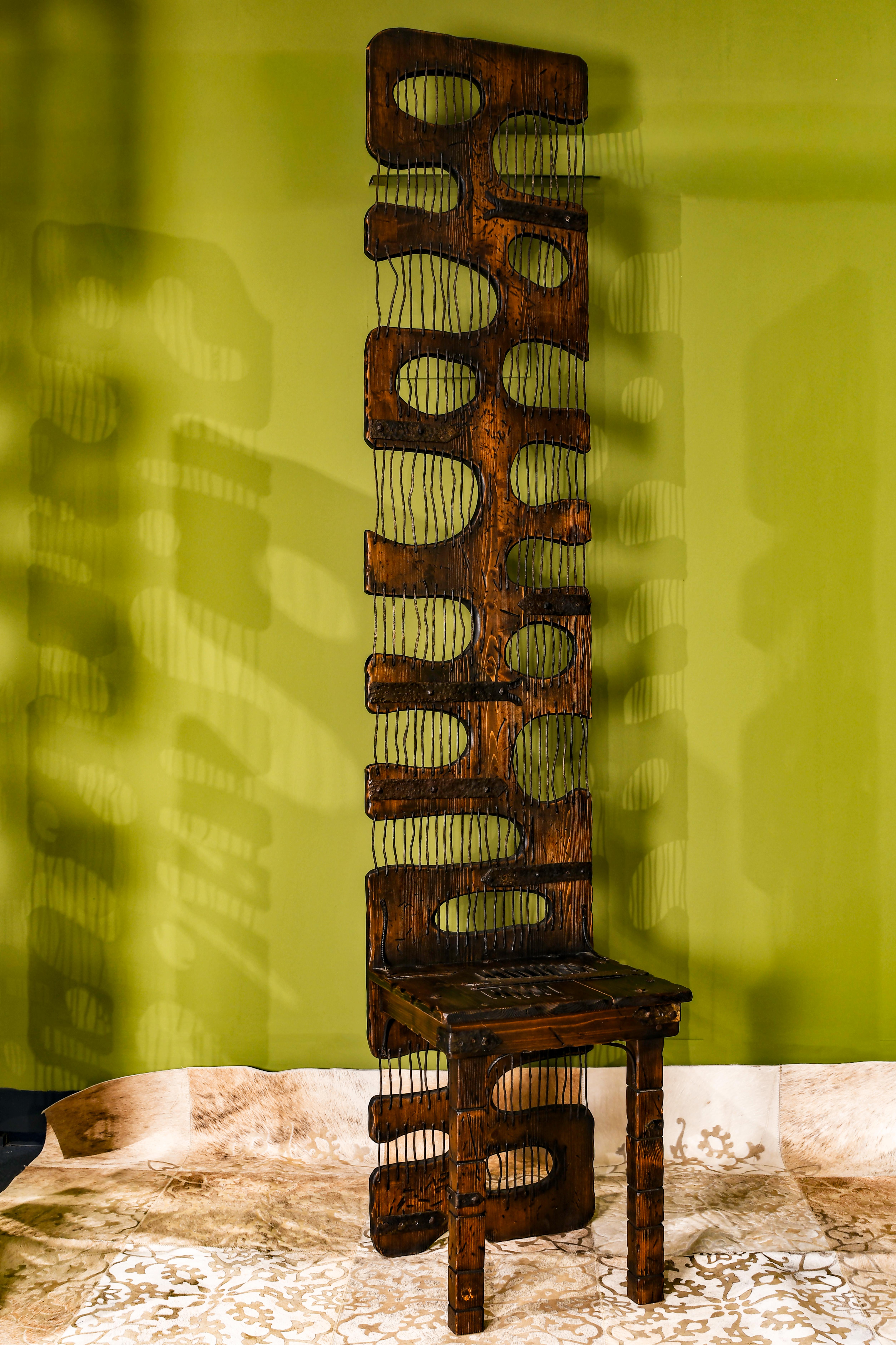 No una simple silla, sino una obra de arte funcional. Creada por Paolo Rossi,  A partir de materiales desechados como: tablones de madera, hierro martillado, un cartel publicitario de aluminio y piezas de acero de máquinas, esta pieza yuxtapone lo
