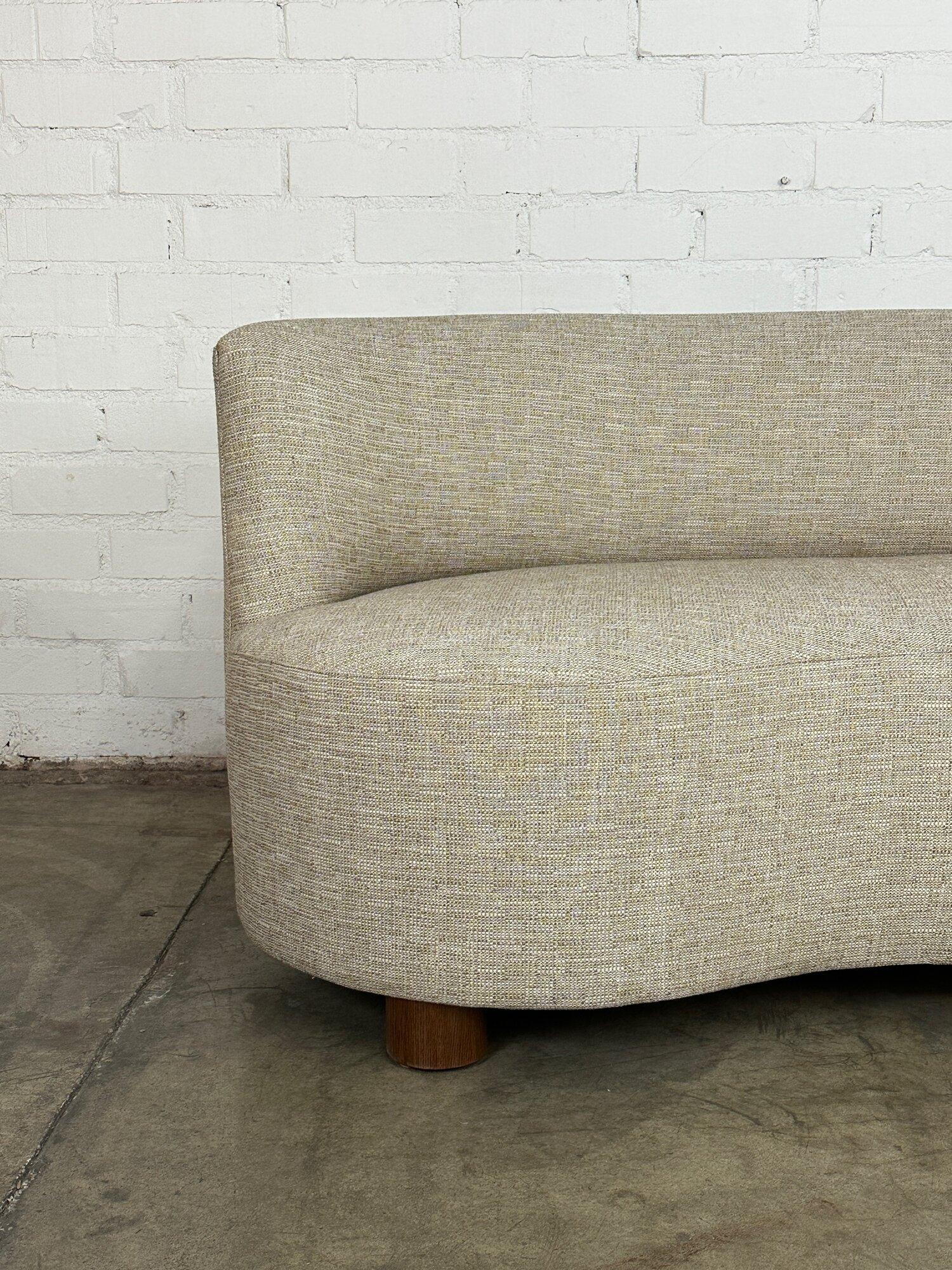 W70 D33 H29.5 SW64 SD23-24 SH17

Kidney sofa completely built from scratch in house in soft tweed and turned white oak legs finished in a dark walnut. Item features a new wooden frame, new foam and new fabric. Legs are removable if needed. Item has