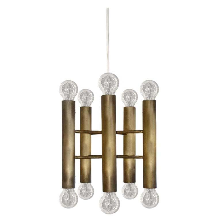 One of... Minimalist solid raw brass chandelier with beautiful patina.
Italy, 1960s.
Measurements:
Diameter (Body) 12.2 in
Height (Body) 10.6 in. (without bulbs)
Lamp sockets: 10x E27 (US E26).