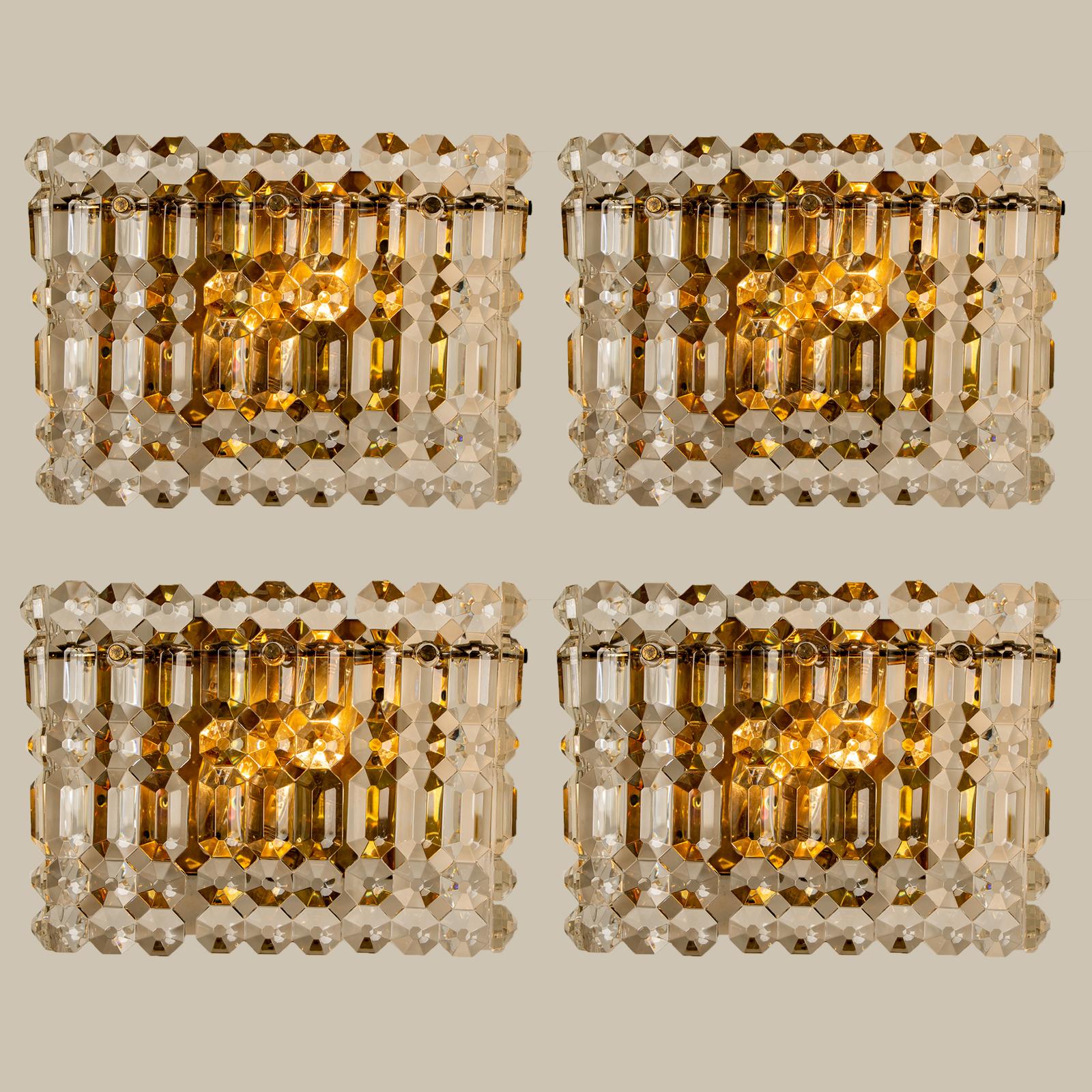 One of the eight luxurious gold-plated frames and thick crystal sconces by the famed maker, Kinkeldey. Two-light sources. Very elegant light fixtures, comfortable with all decor periods. The crystals are meticulously cut in such a way that radiate