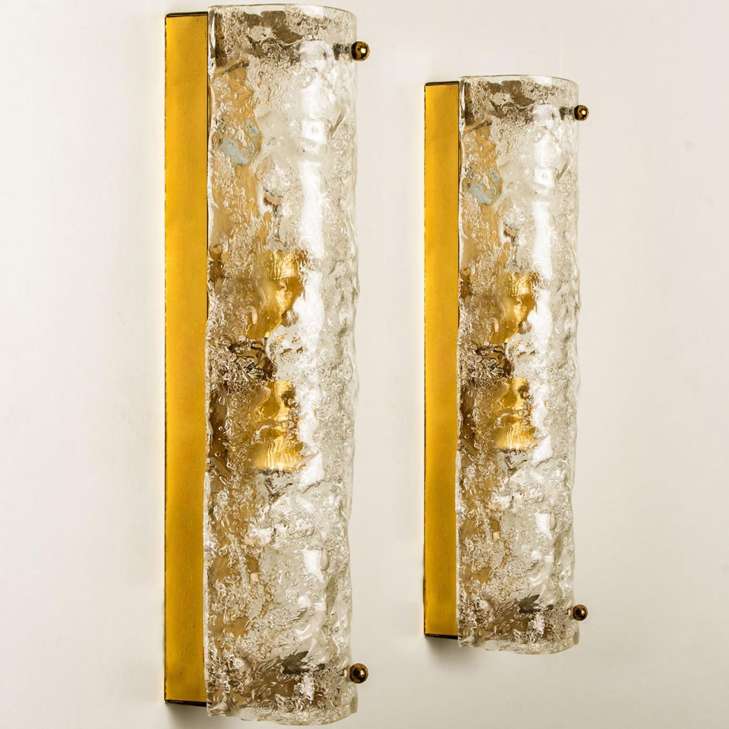 L'une des quatre appliques haut de gamme en verre de Murano sur une base en laiton fabriquées en Allemagne, vers les années 1960. Longueur 13,8 pouces
Il se compose d'un abat-jour tubulaire en cristal clair de qualité texturée simulant la glace sur