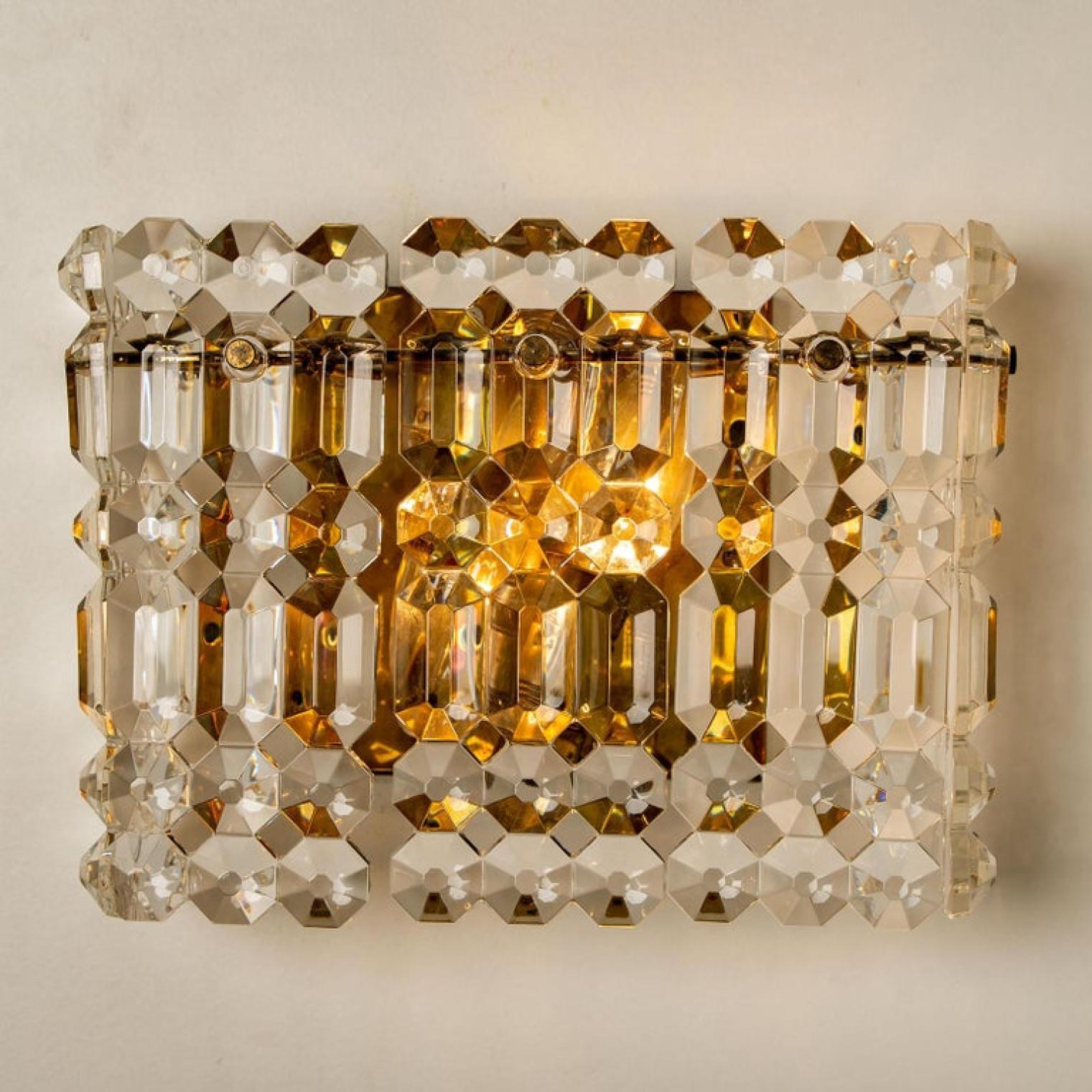 One of the four luxurious gold-plated frames and thick crystal sconces by the famed maker, Kinkeldey. Two-light sources. Very elegant light fixtures, comfortable with all decor periods. The crystals are meticulously cut in such a way that radiate