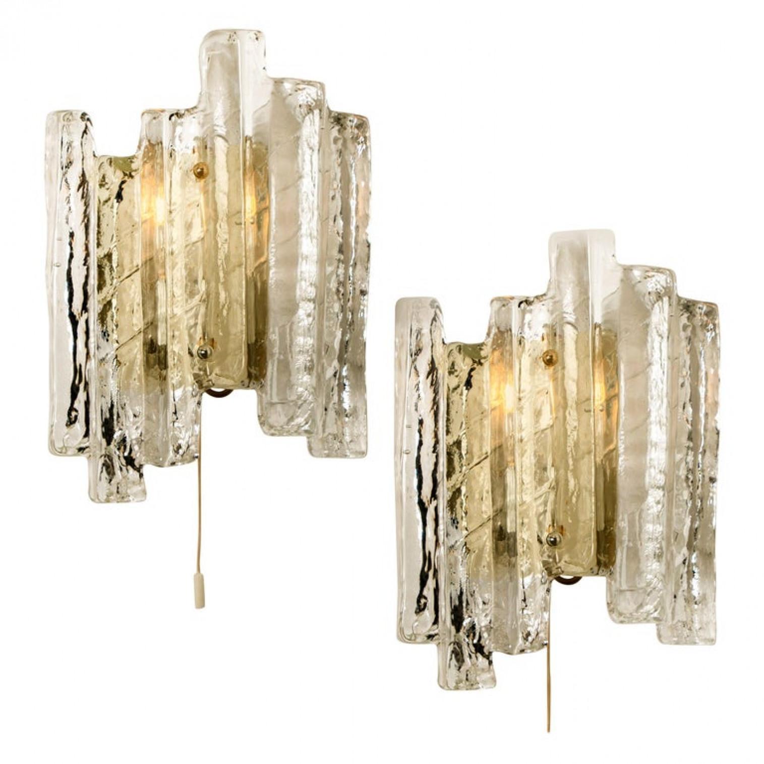 One of the six elegant modern high-end large brassed topped metal lights or sconces, Austria in the 1970s. Lovely design, executed to a very high standard. Each wall light has four solid ice glass sheets dangling on it. Clean lines to complement all