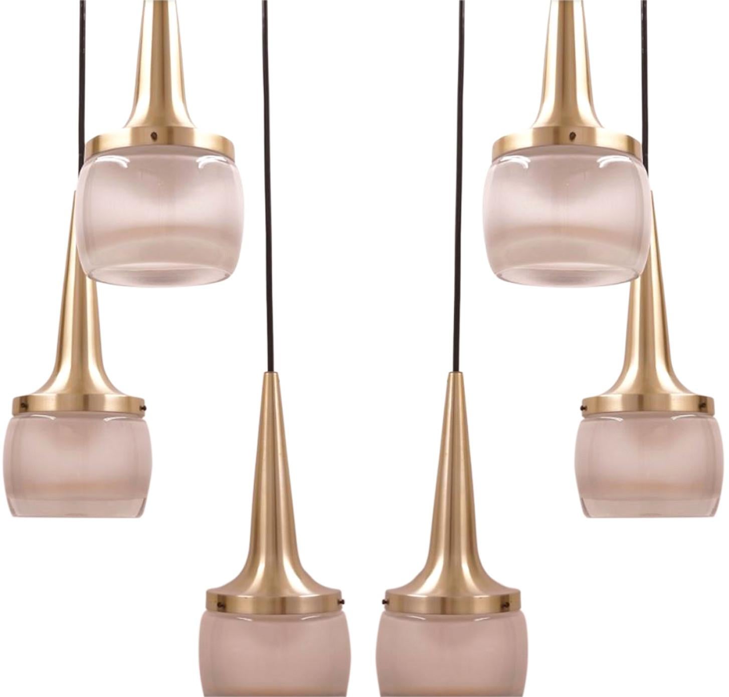 This pair of elegant cascade light fixtures was manufactured by Staff Leuchten in Germany. The light is executed in brassed aluminium and thick off white opaline molded glass etched on the inside.

Each individual pendant measures: 13.5 in. H x 5.25