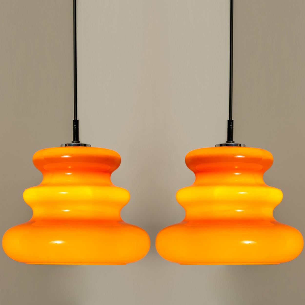 There’s something about orange that screams this particular era. And this 1970s pair of Peill & Putzler ceiling pendant lamps is very orange!

The lovely shaped hand blown lampshade is made of a ‘cast opaque orange glass’ with an inner white