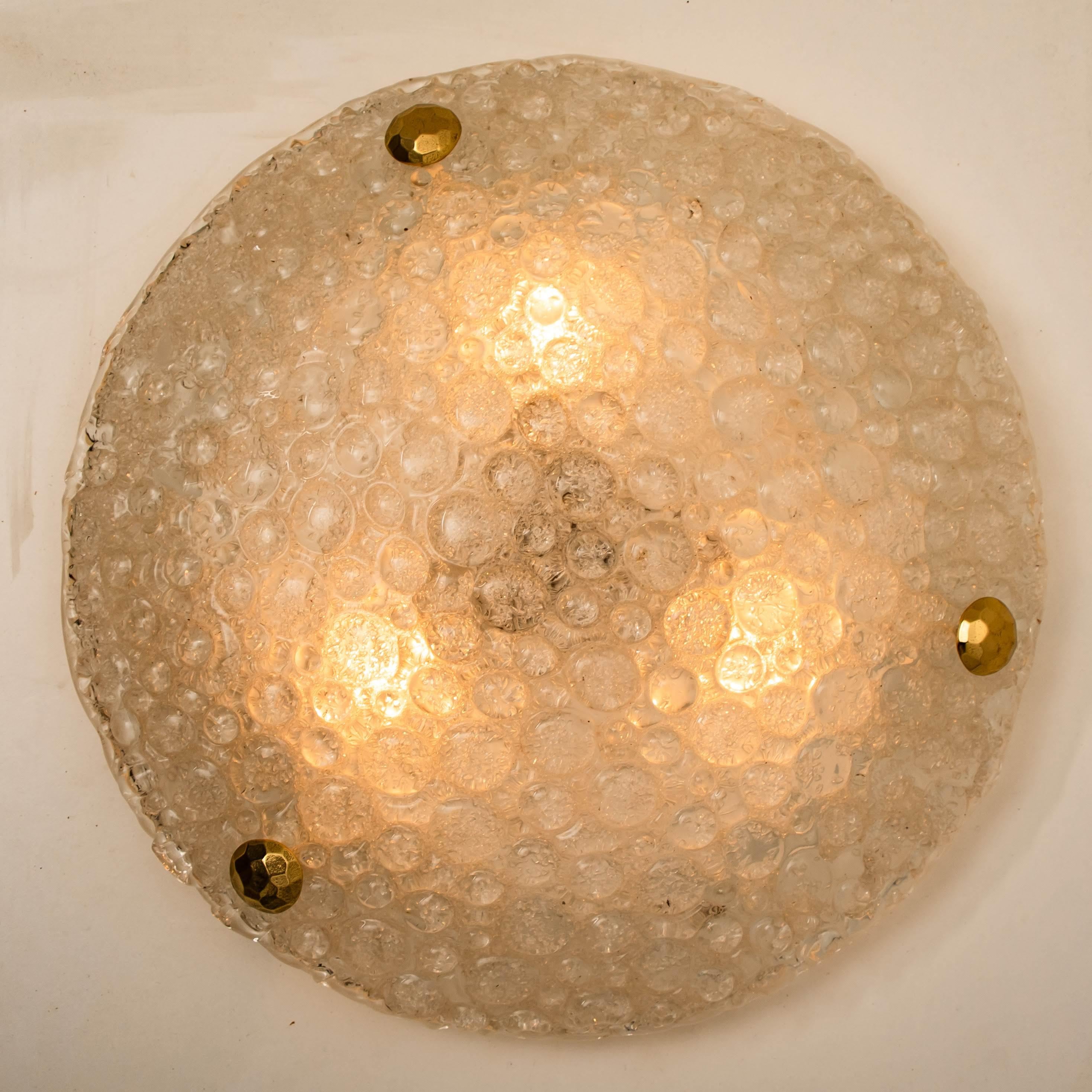 Stunning high-end brass and Murano glass wall light by Hillebrand. Manufactured in the late 1960s-early 1970s. The brass backplate holds a huge heavy blown glass with three brass brackets. The think glass has a beautiful textured structure.