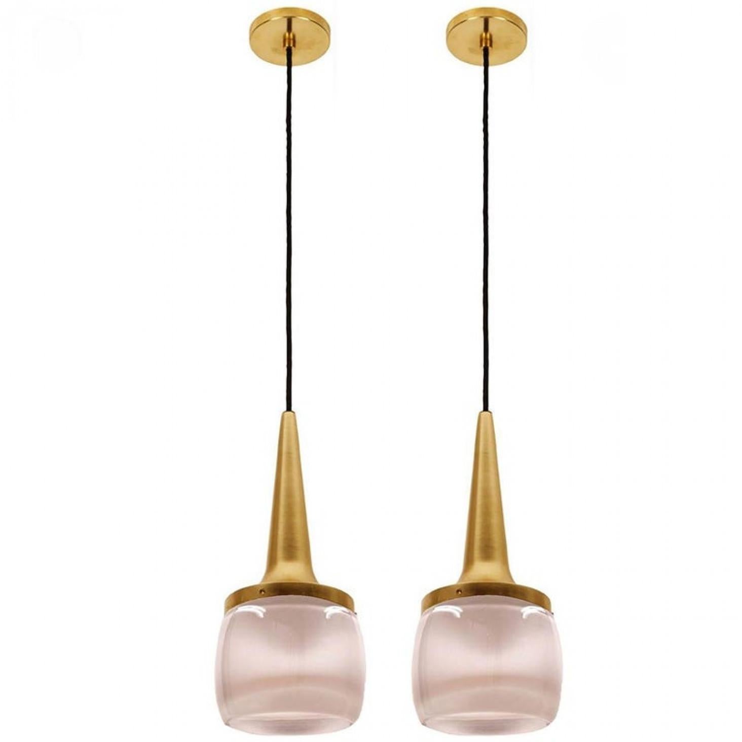 Cette paire d'élégants luminaires en cascade a été fabriquée par Staff Leuchten en Allemagne. Le luminaire est exécuté en aluminium laitonné et en verre moulé opalin blanc cassé épais gravé à l'intérieur.

Chaque pendentif individuel mesure 13.5 in.