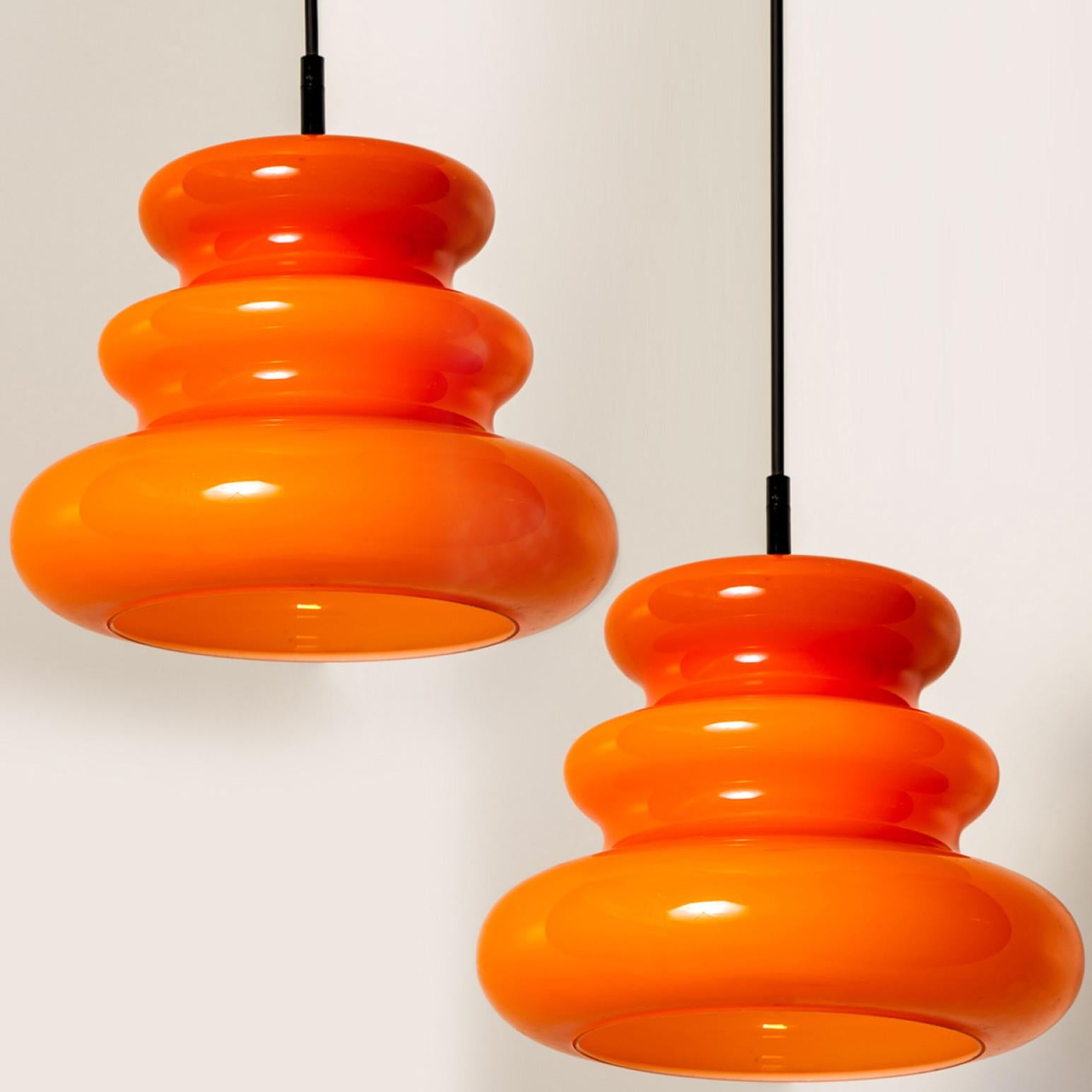 There’s something about orange that screams this particular era. And this 1970s pair of Peill & Putzler ceiling pendant lamps is very orange!

The lovely shaped hand blown lampshade is made of a ‘cast opaque orange glass’ with an inner white