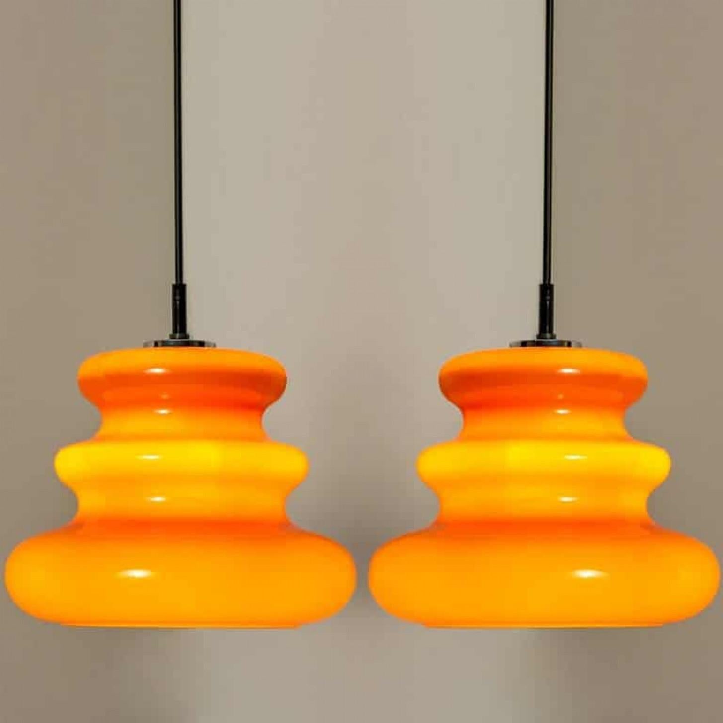 C'è qualcosa nell'arancione che fa pensare a questa particolare epoca. E questa coppia di lampade a sospensione da soffitto Peill & Putzler degli anni '70 è molto arancione!

Il grazioso paralume soffiato a mano è realizzato in 