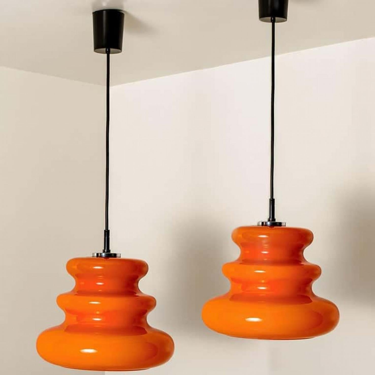 Vetro soffiato Una delle due lampade a sospensione arancioni di Peill & Putzler, anni '70 in vendita