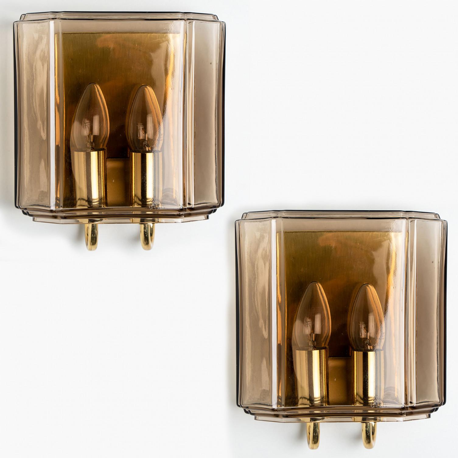 This beautiful pair of hand blown glass wall lights were manufactured by Glashütte Limburg in Germany during the 1960s (late 1960s-early 1970s). Beautiful craftsmanship. These mid century vintage lights feature handmade, elaborate smoked glass with