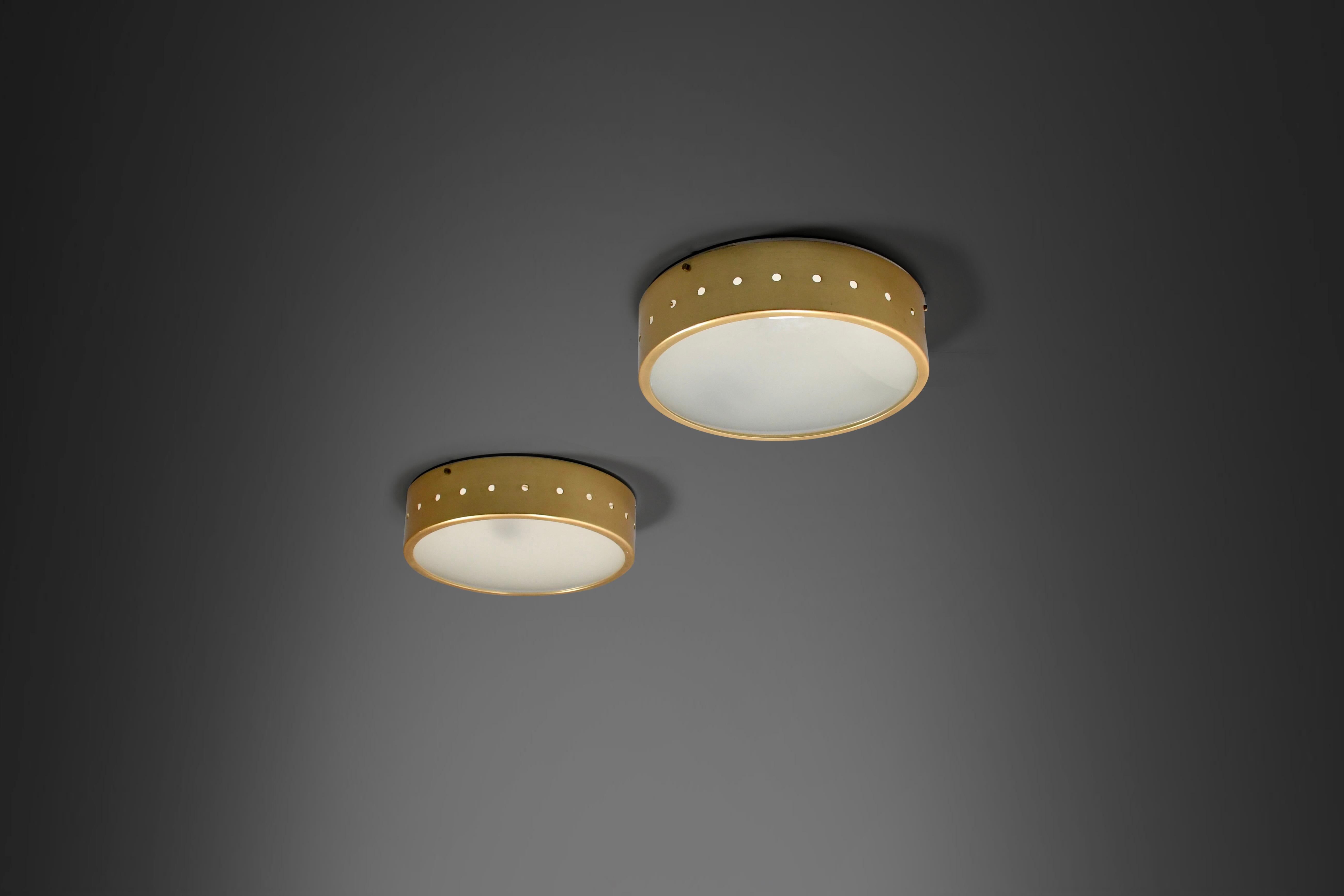 Two beautiful flush mounts in very good original condition.

Manufactured by Stilux Milano in the 1960s.

These round shaped flush mounts are made from brass, the base is lacquered white, holding three sockets.

The brass ring that holds the opaline