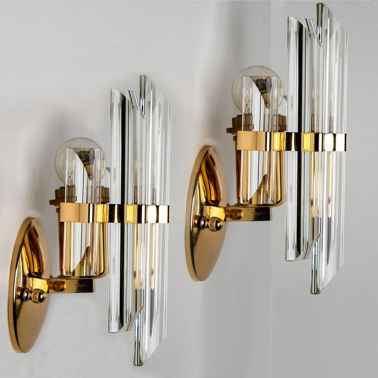 Einer der drei Murano-Glas-Wandleuchter mit fünf Prismenstäben aus kristallklarem Glas, mit Messingdetails und Rückwand. Leuchtet wunderschön. Hochwertige Stücke.

Gereinigt und gut verkabelt, voll funktionsfähig und einsatzbereit. Das Messing und