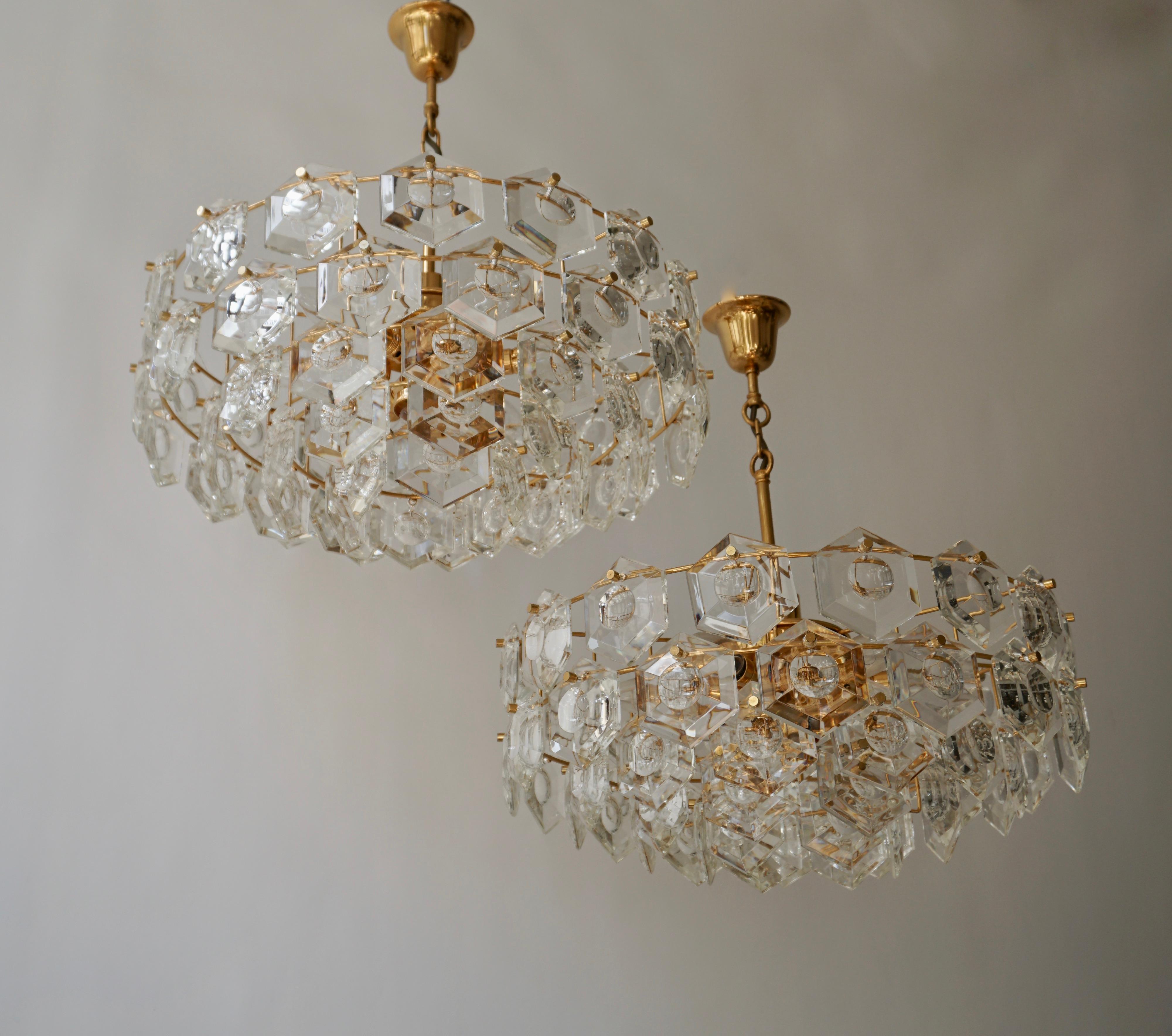 Two chandeliers with sculptural faceted crystals on a gold-plated brass frame made by Kinkeldey, Germany in the 1960s.
The lamp takes one large and six small Edison base bulbs.
Very good condition.

Measures:
Diameter 52 cm.
Height fixture 23