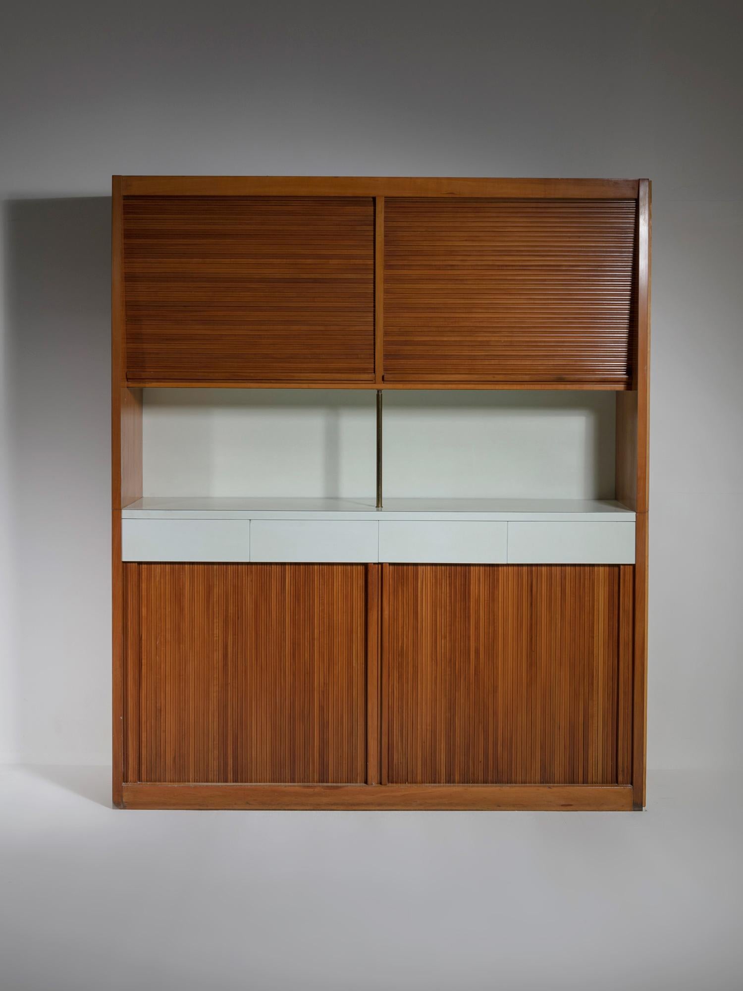Capable storage piece by Osvaldo Borsani.
Lower and top units with rolling doors and central area with four drawers and brass frame.
Literature available upon request.