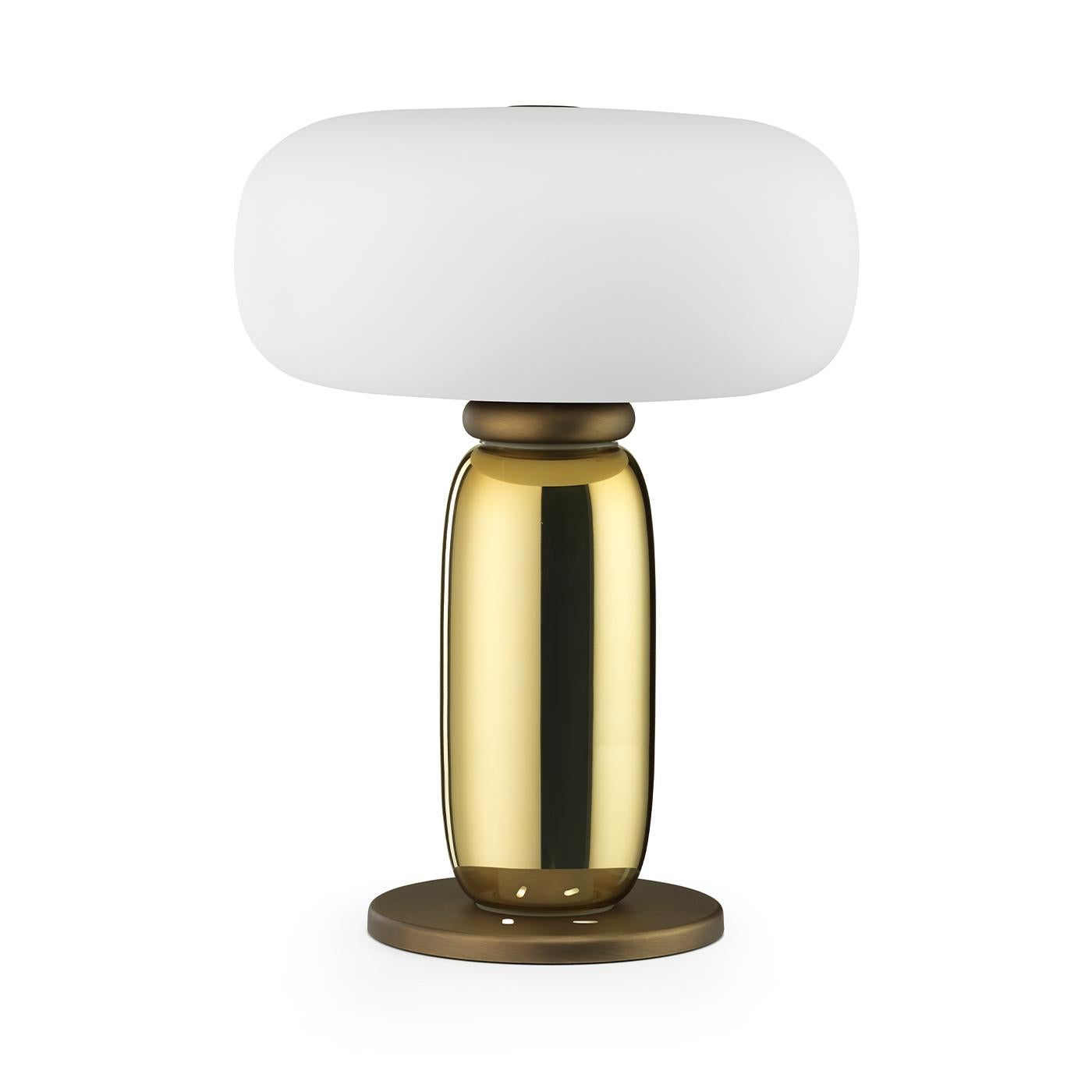 Marked by clean and soft lines, this modern table lamp will effortlessly elevate the style of any room in both modern and traditional decors. Superbly handcrafted, it features a round brass base supporting a glass body finished in a mesmerizing