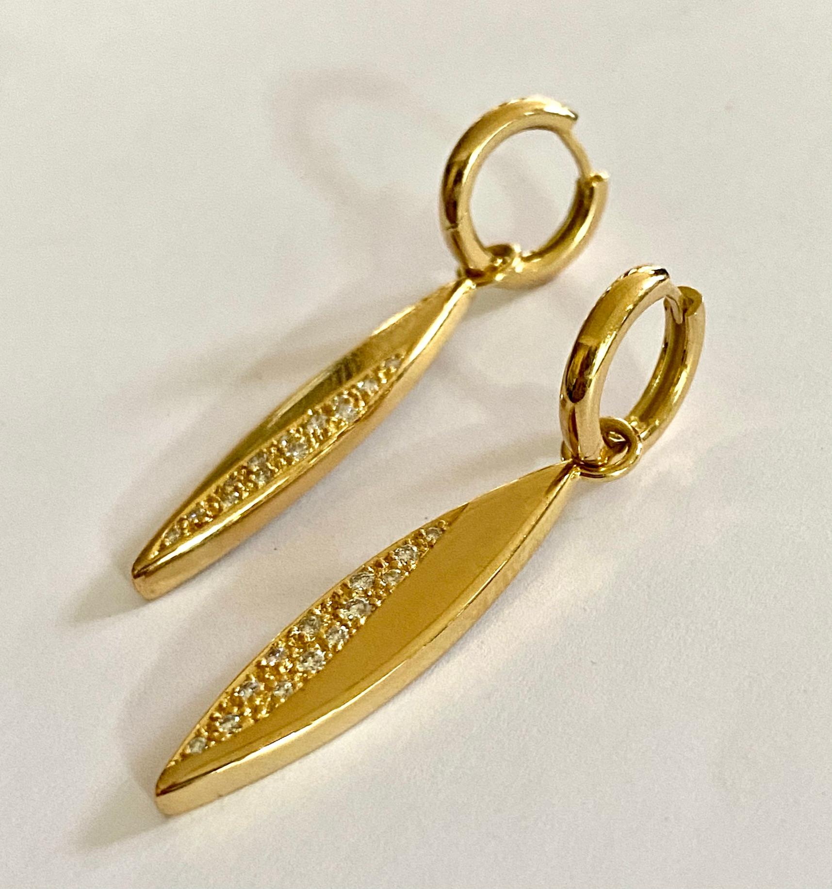 A pair of 18K. yellow gold earrings consisting of a hoop of 13 mm diameter (hinge) and a pastil-shaped attachment of 32 x 7.5 x 2 mm. Stamped: 750 and F + (brilliant mark).
set with 26 brilliant cut natural diamonds weighing together: 0.40 ct.
